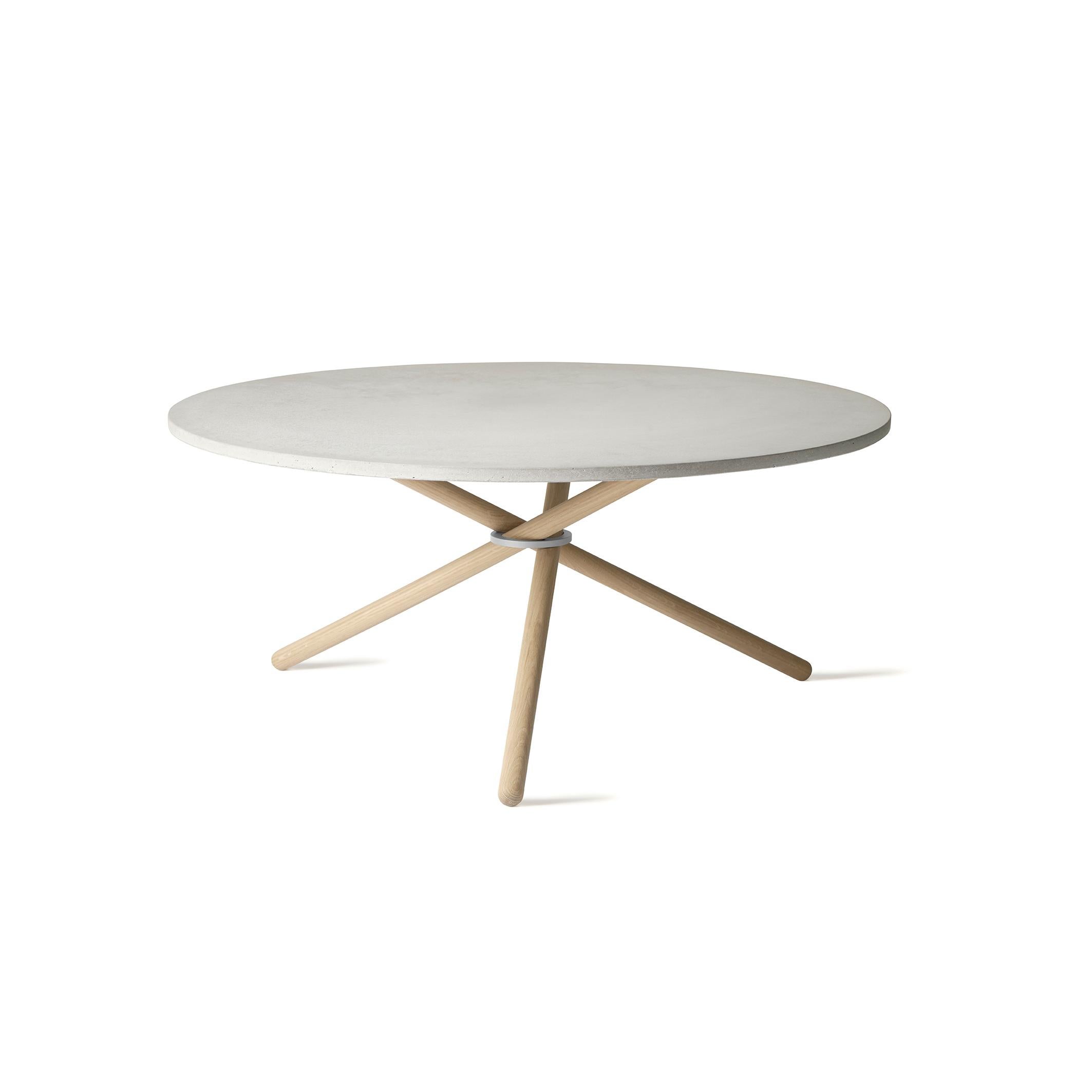 Edda ist ein geräumiger Couchtisch mit einem Durchmesser der Tischplatte von 105 cm. Der Tisch besteht aus drei Unterelementen: Der Montagering, die Holzbeine und die Tischplatte aus Beton, Eiche oder Birke. Die fast schwebende Tischplatte und die