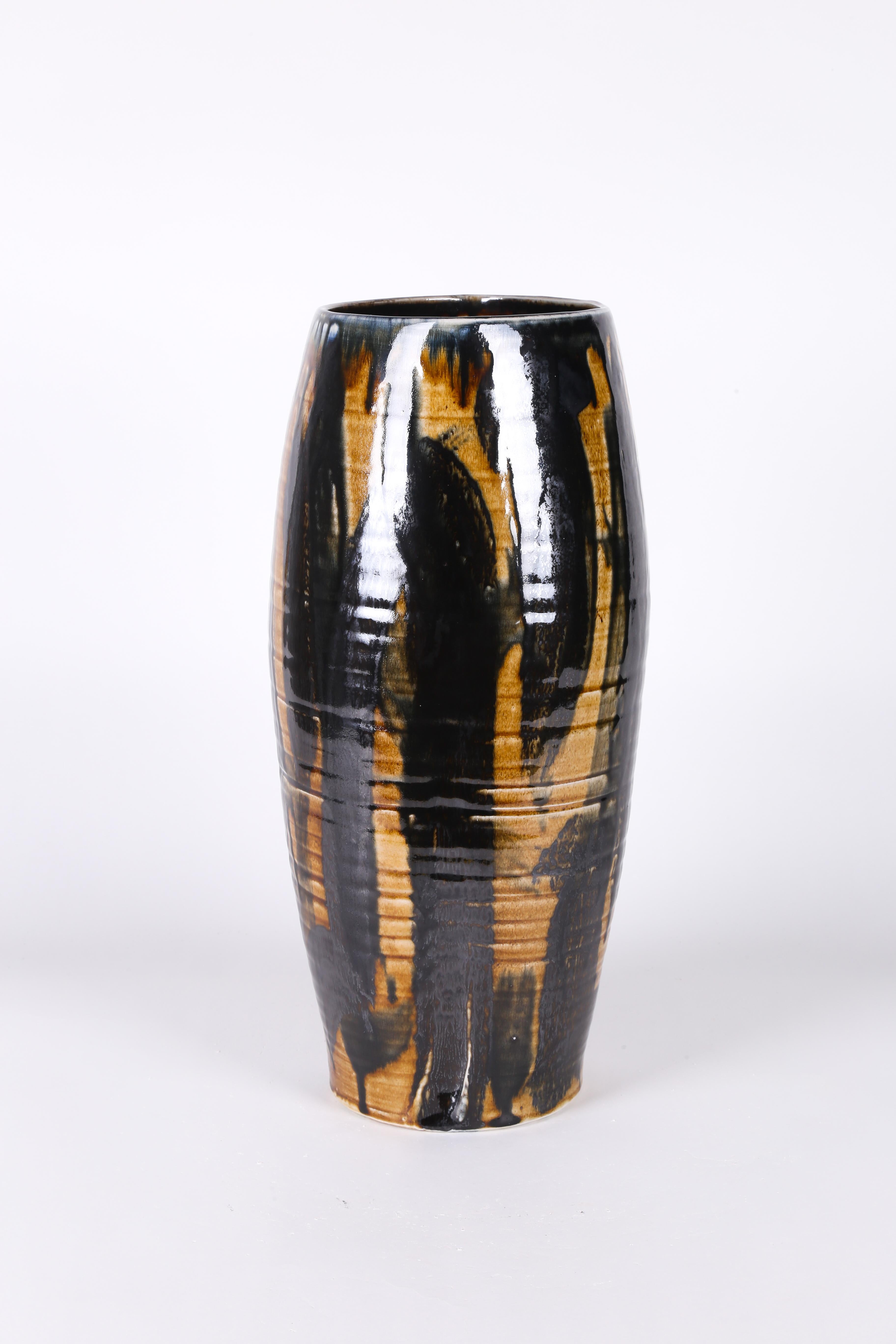 This elegant decorative ceramic vase in earth tone glaze by Black artist and potter Ebitenyefa Baralaye is a beautiful vessel that would look great upon a bookshelf or side table. This ceramic art object is made of stoneware, and covered in various