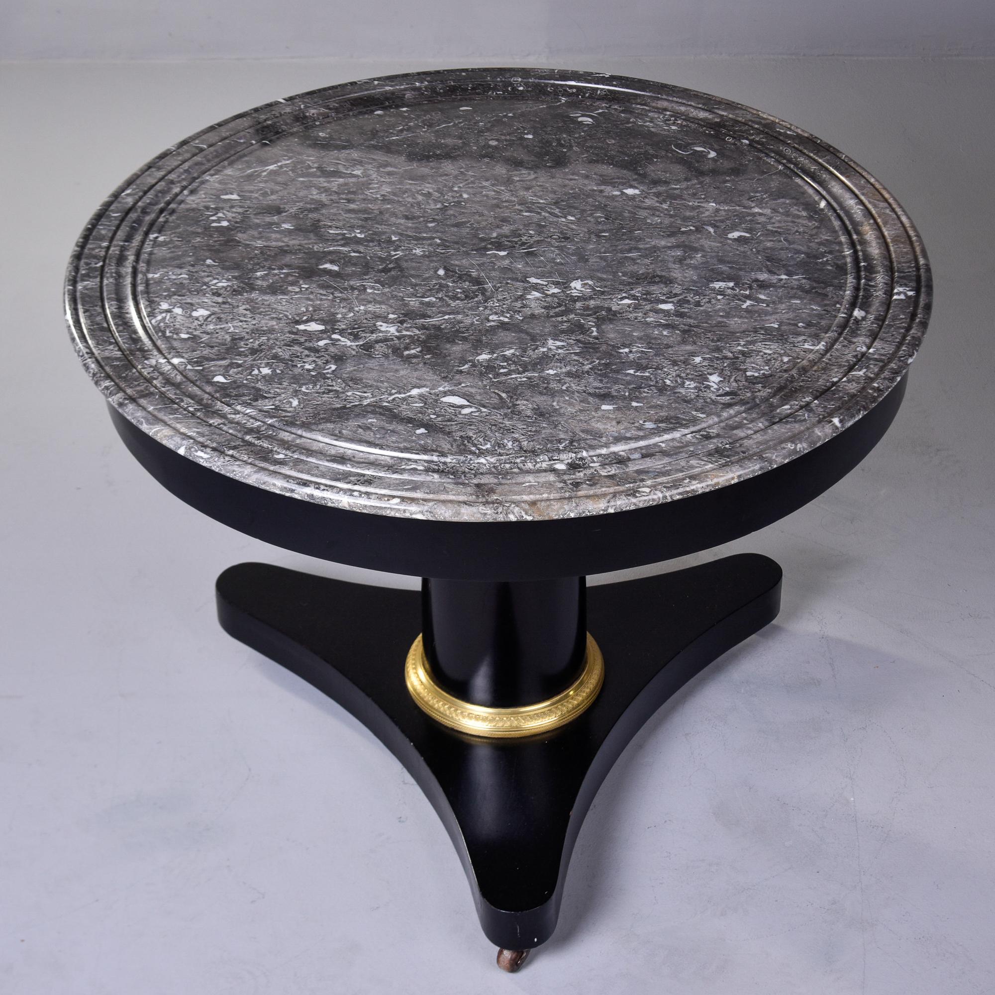 Found in France, this circa 1840s mahogany empire center table has a new, professionally applied ebonised finish. Gray and white streaked round marble top with a brass trimmed trefoil base on casters. Unknown maker.

Very good overall antique