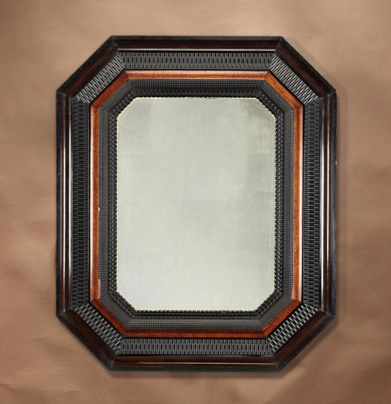 An ebonised and amboyna octagonal mirror.

In the 17th Flemish century style, the shaped plate within a ripple moulded frame.

