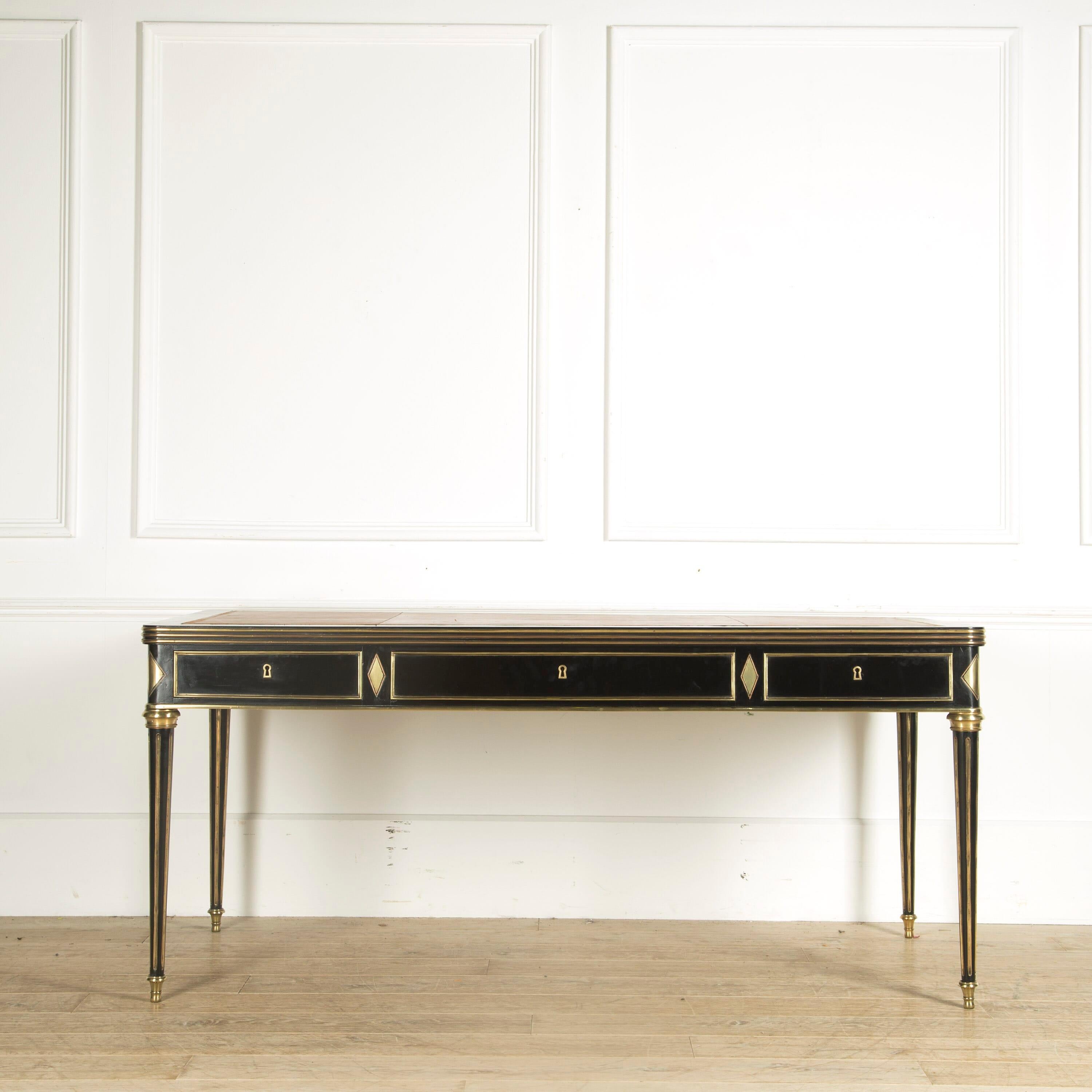 A mid-20th century French ebonized and brass-mounted bureau plat of the style and quality associated with Maison Jansen manufacture during this period. France, circa 1960.