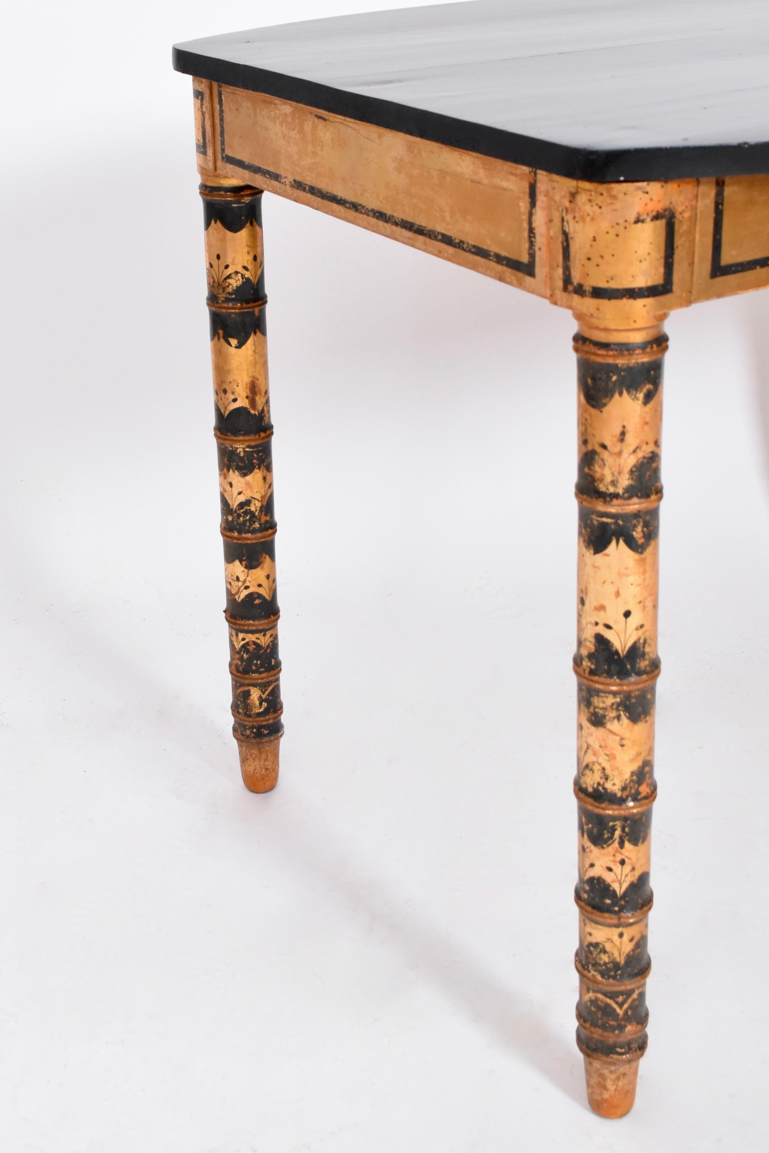 Rectangular Art Nouveau console writing table, or desk with an ebonised table top and a gold and black geometrical pattern painted feet. France, 1920s.