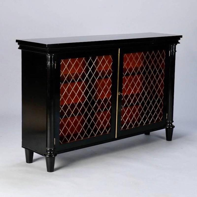 English sideboard has new professionally applied ebonised finish and open diamond weave decorative brass grill inserts on two front doors that lock with skeleton key, circa 1920s. Two adjustable height shelves. Tops of shelves and Inside back of