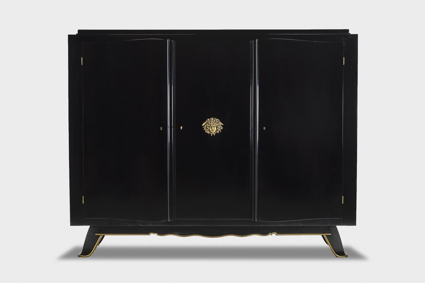 Exceptional French 1930s ebonised 3-door cabinet with gilt brass mounts and sycamore veneered interior.



