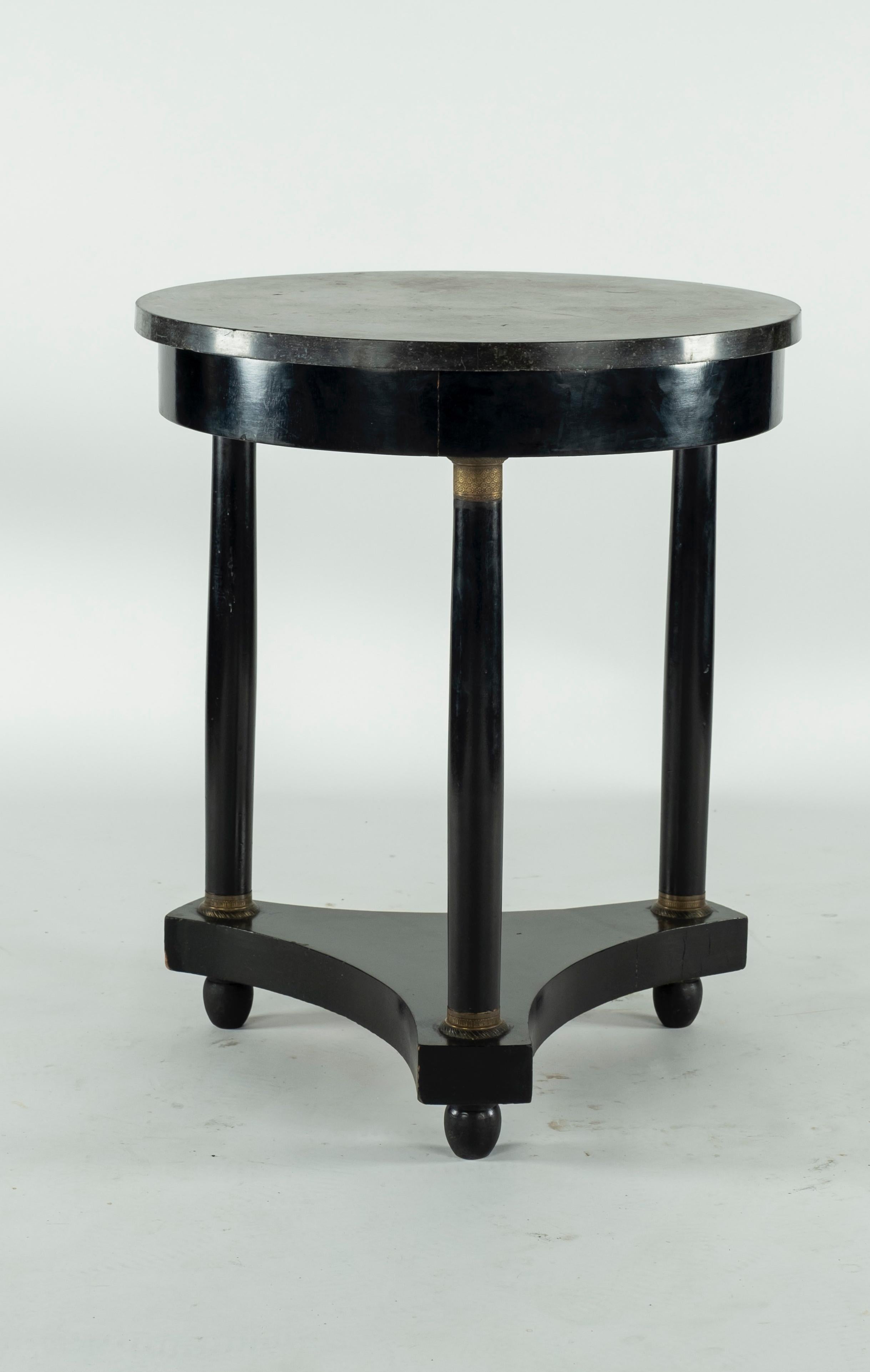 Ebonised French Gueridon with Fossil marble top on 3 oblong bun feet. Metal detail on each of the three columns along the top and the bottom.