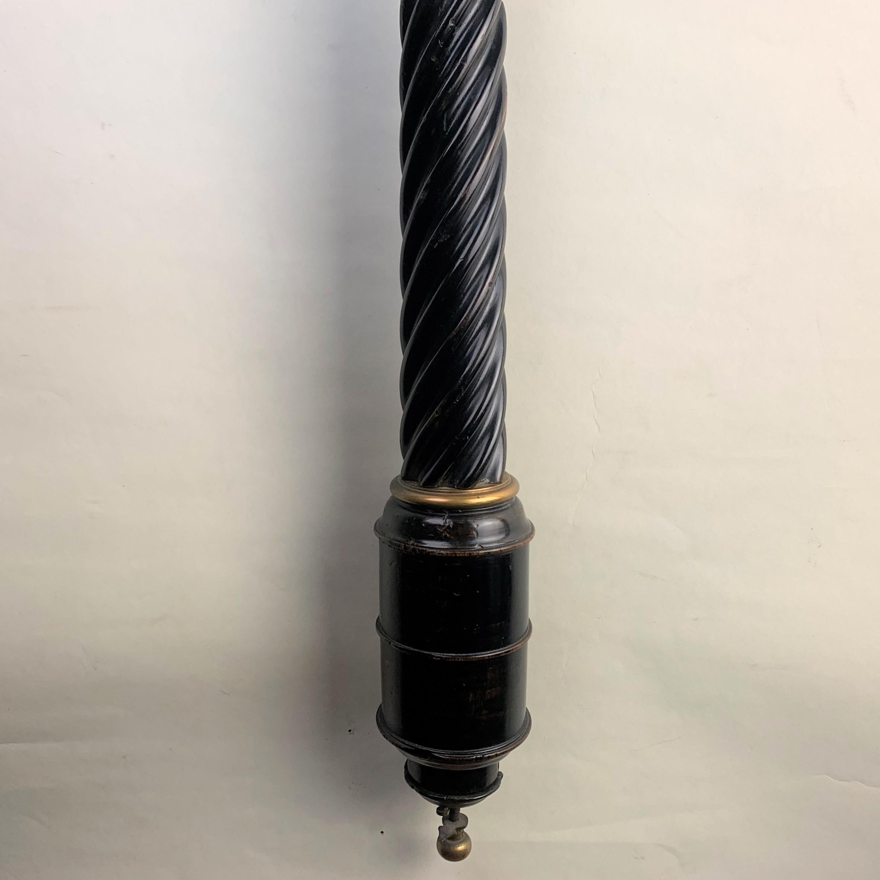 A rare unsigned ebonised fruitwood and brass-mounted siphon tube barometer. The barrel-shaped cistern base has the brass adjustment knob in the base and a gilt-brass collet at the top joining it to the spiral section with a further brass collet,