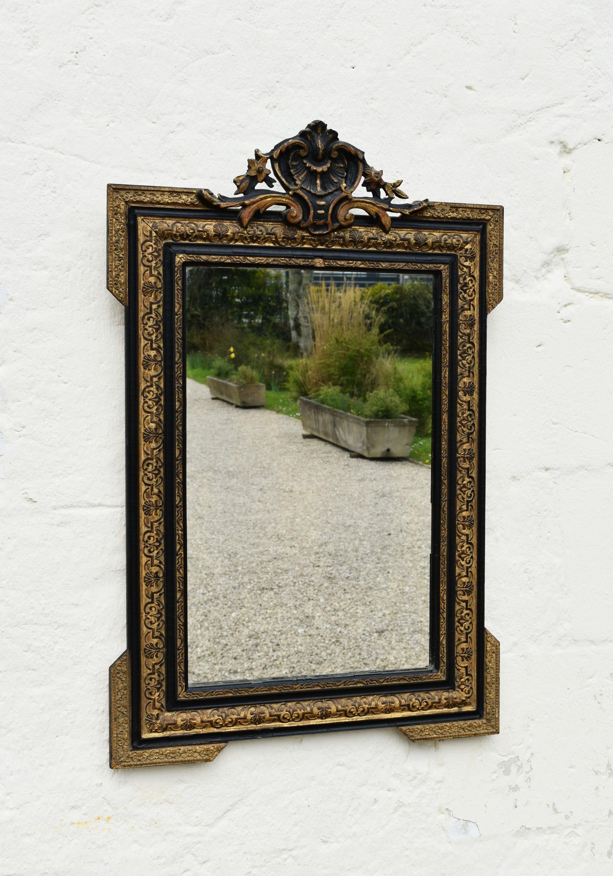 Specchio ebanizzato e in legno dorato Napoleone III Secondo Impero

Proveniente dalla regione basca della Francia sud-occidentale, questo splendido specchio presenta uno stemma in rilievo con eleganti decorazioni floreali e di foglie