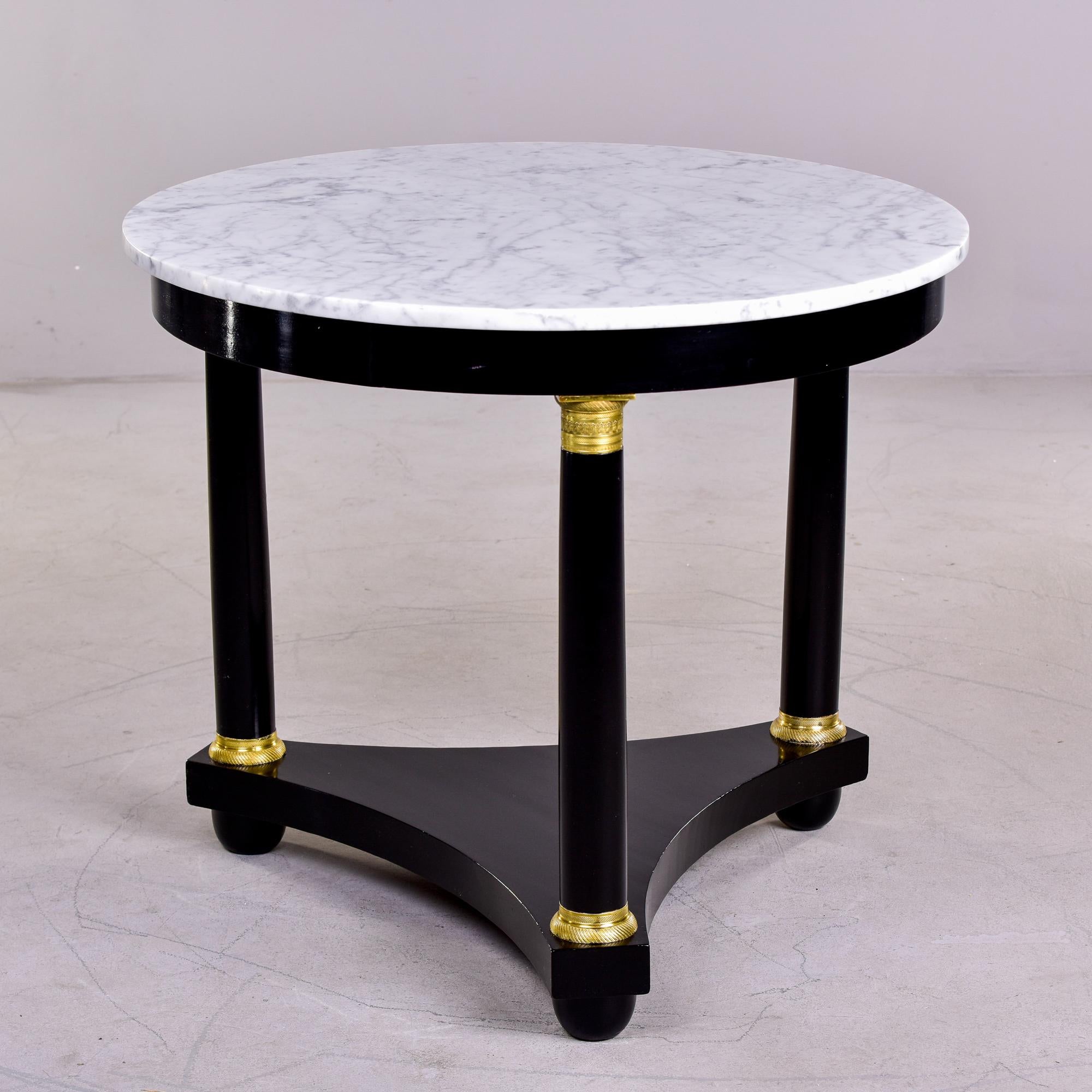 Found in France, this circa 1920s Louis XVI style side table has a new ebonized finish, three legs with a triangular base, brass trim and a white marble top with gray veining. 

Very good antique condition. Minor surface wear to marble and wood.