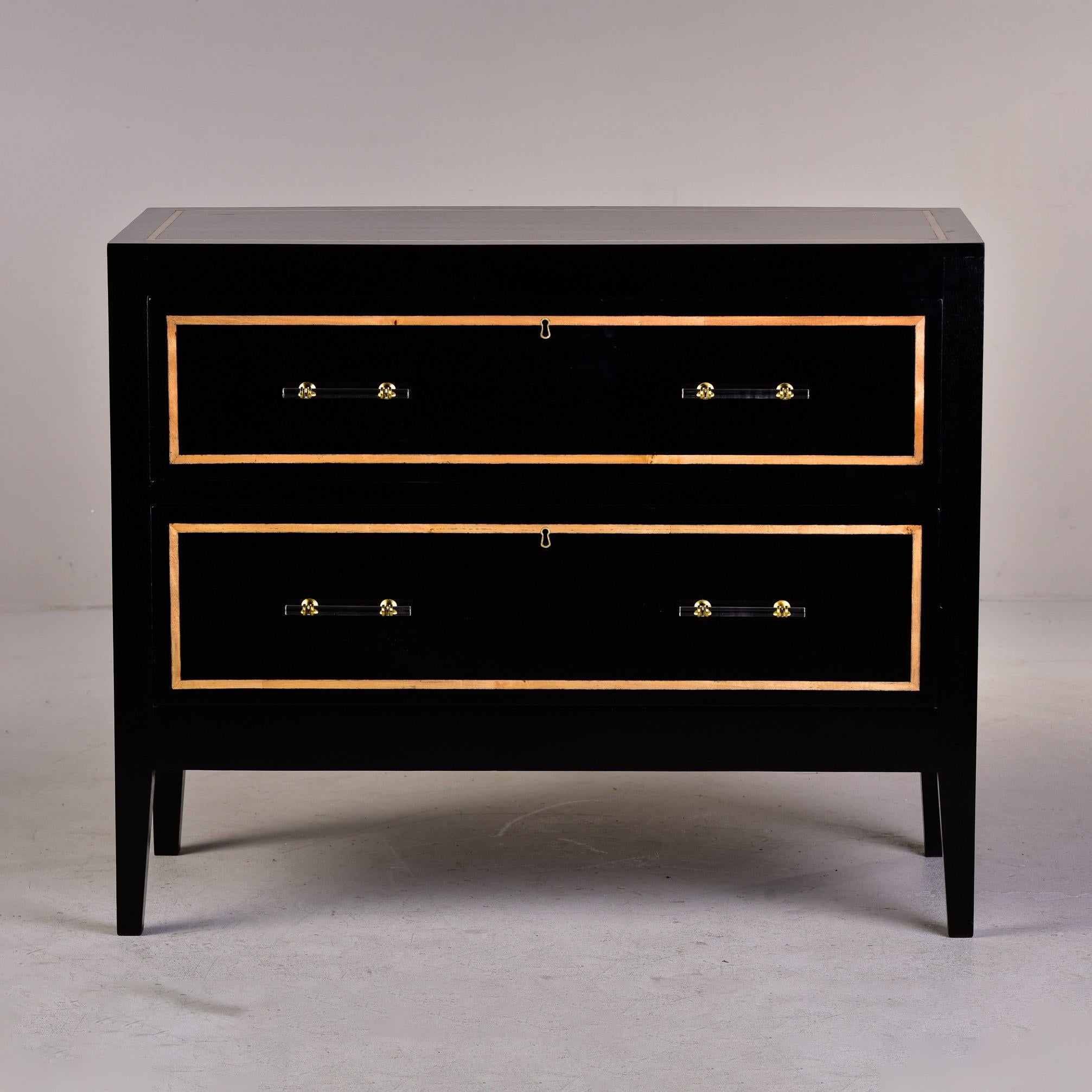 Found in England, this circa 1930s two drawer chest has an ebonised finish and decorative contrasting inlay on drawer fronts, top and side panels. New brass and lucite hardware. Unknown maker.