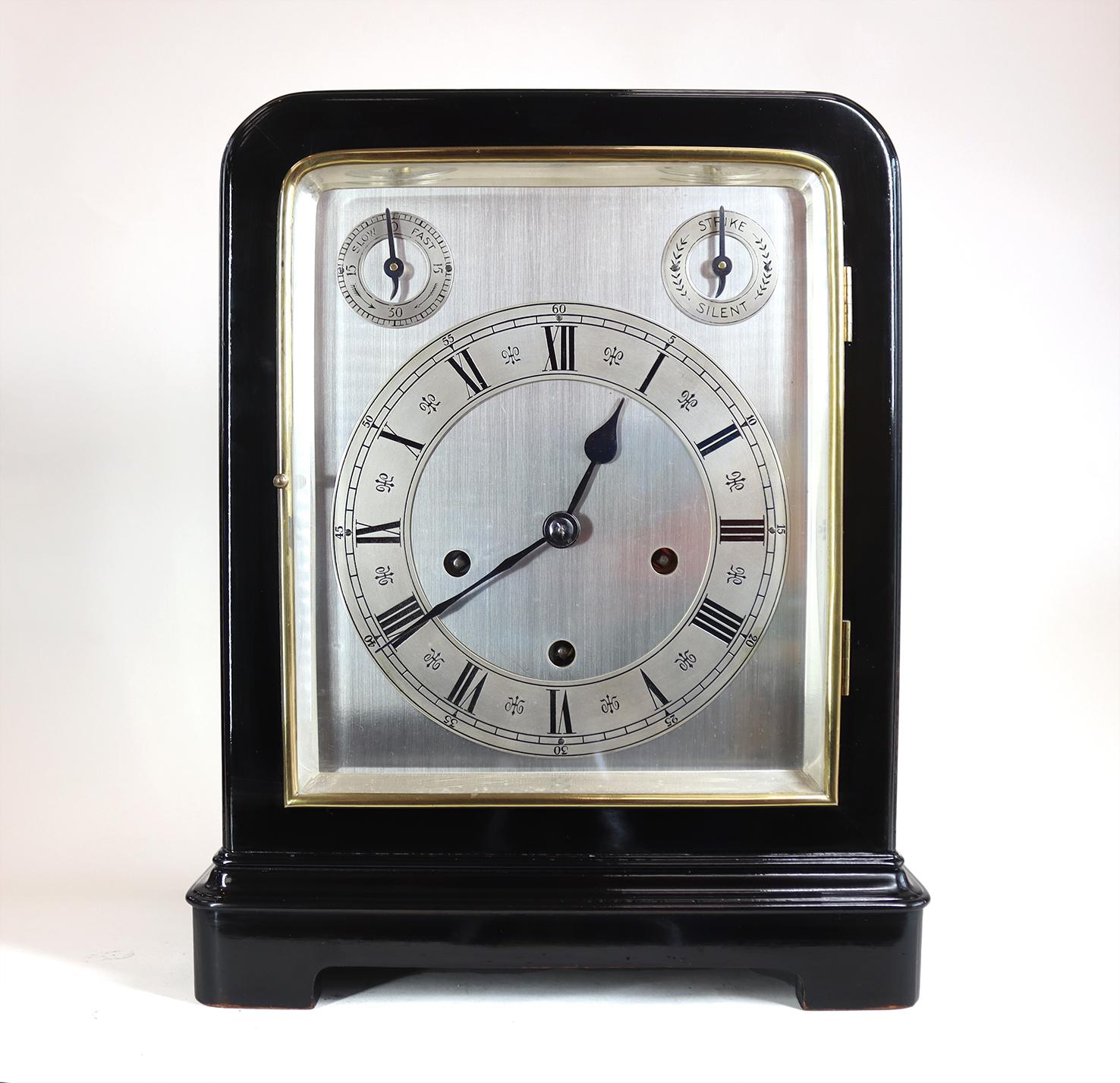 A very stylish late 19th century bracket clock in an ebonised case with heavy bevelled glass to all sides and top, with a pristine silvered dial and roman chapter ring below strike silent and time keeping adjustment dials, behind a brass bezel and