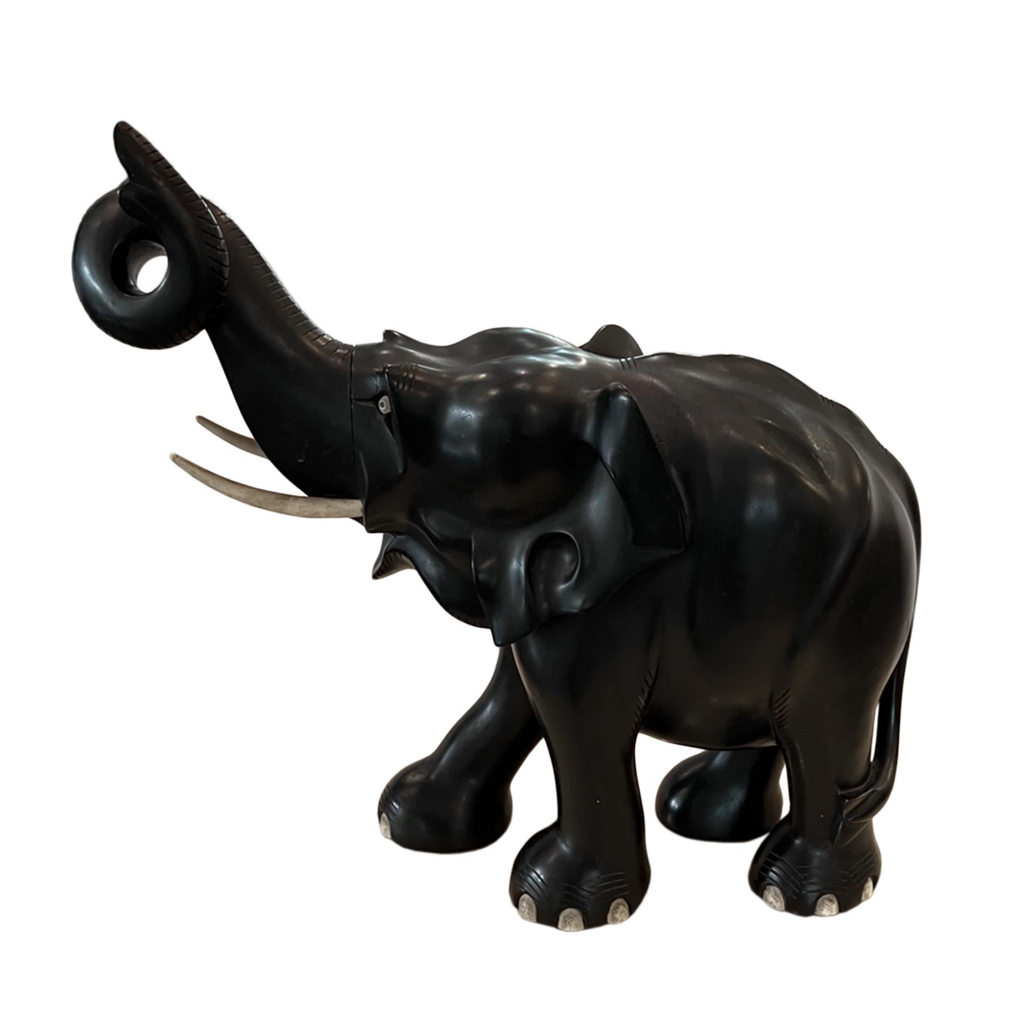 This is a lovely large decorative wood elephant sculpture which was carved in Cylon in the early 20th century. 

The tusks, eyes and toenails are wood - no ivory.