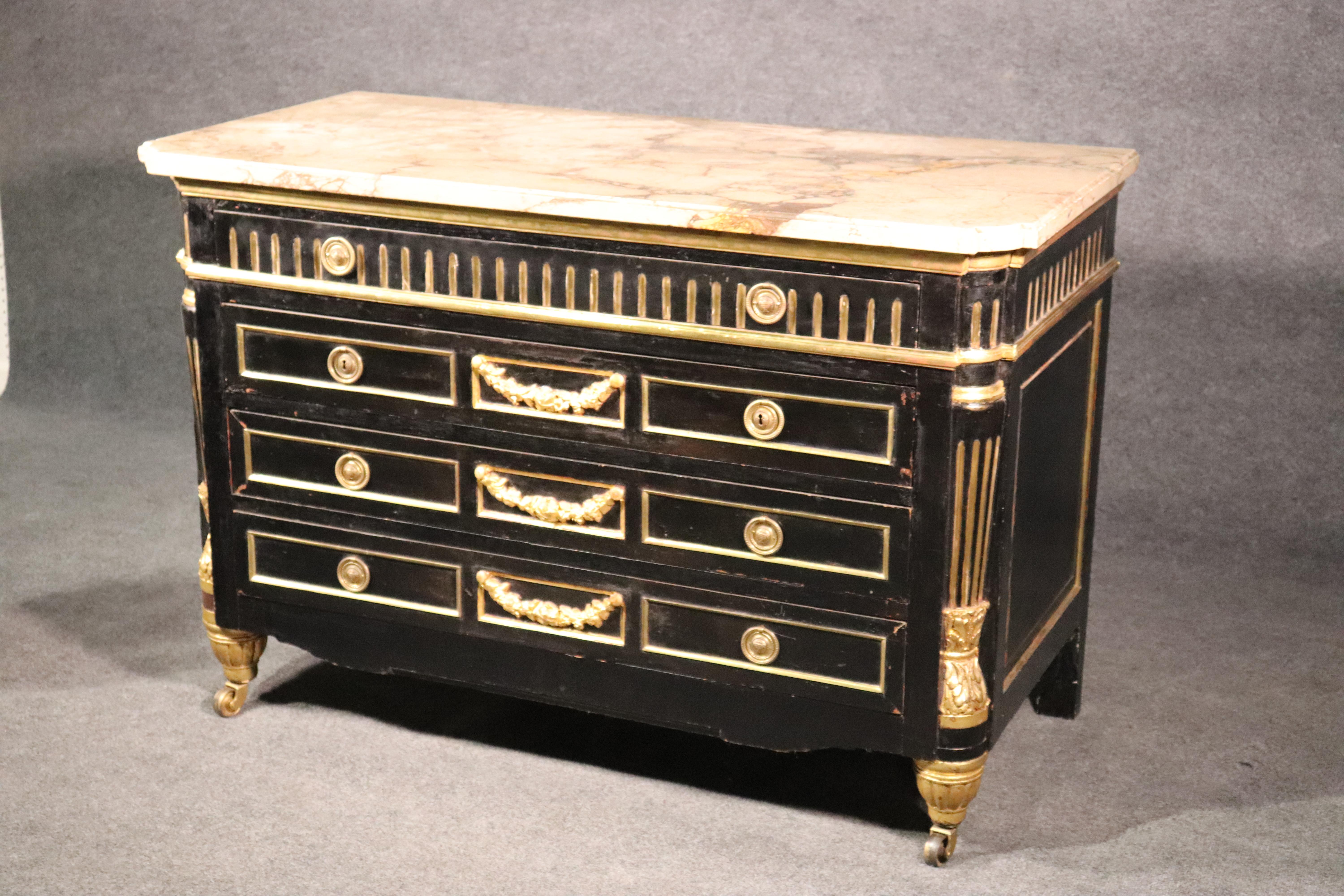 This is a massive and beautifully designed Russian 1870s commode. Dressed in fine water-gilded carved details and a fantastic marble top, this incredible commode measures 52 wide x 25 deep x 35 tall. There are keyholes but no locks were ever in