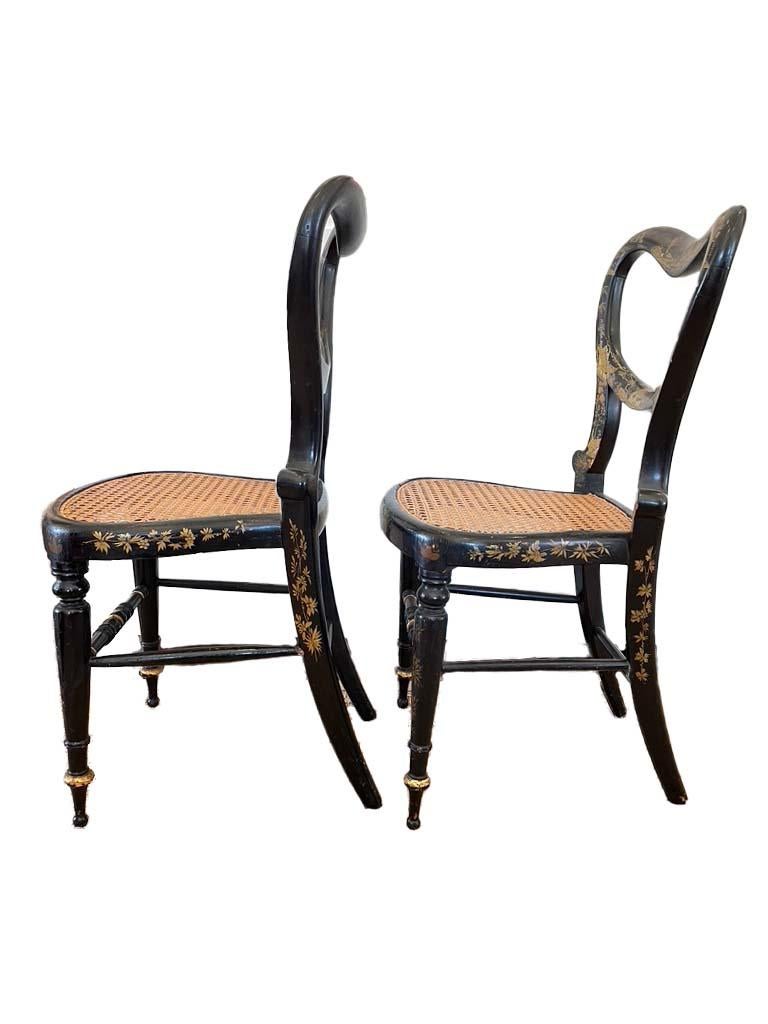 Lovely and unusual ebonized and gold leaf painted chairs with chinoiserie style and floral scenery. These chairs were purchased in Austria but are in the regency style. in wonderful shape.