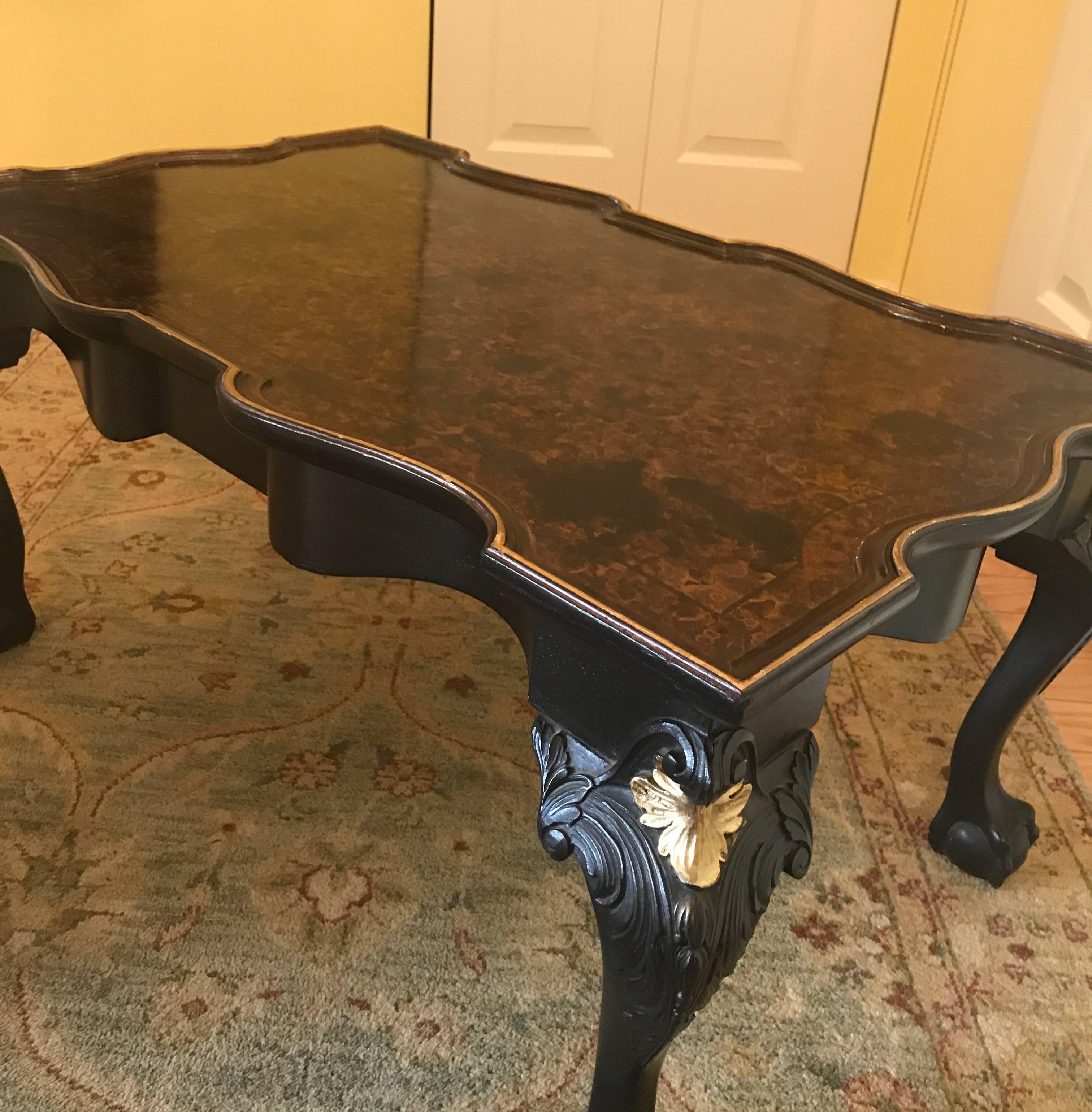 Elegant hand-carved ebonized wood table with a faux tortoise shell top. The shapely scalloped shape with curved and carved legs with gilt shell in the top. The tortoise surface with gilt outline over nicely carved cabriole legs.