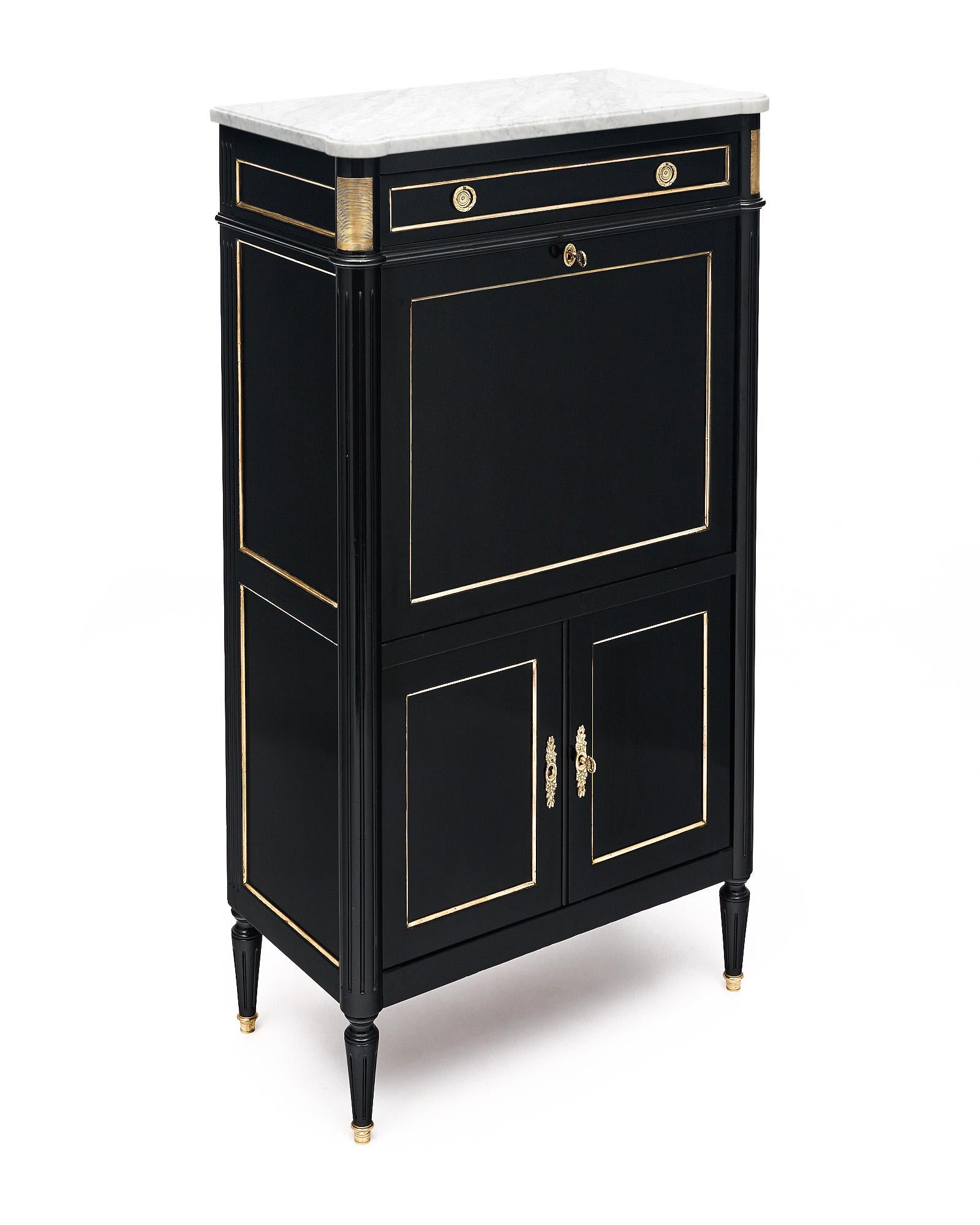 Secretary, drop front desk, from France, of Mahogany in the Louis XVI style. This cabinet is finished in a lustrous museum quality ebonized French polish. There are two lower doors with working lock and key that open to interior shelving. The drop