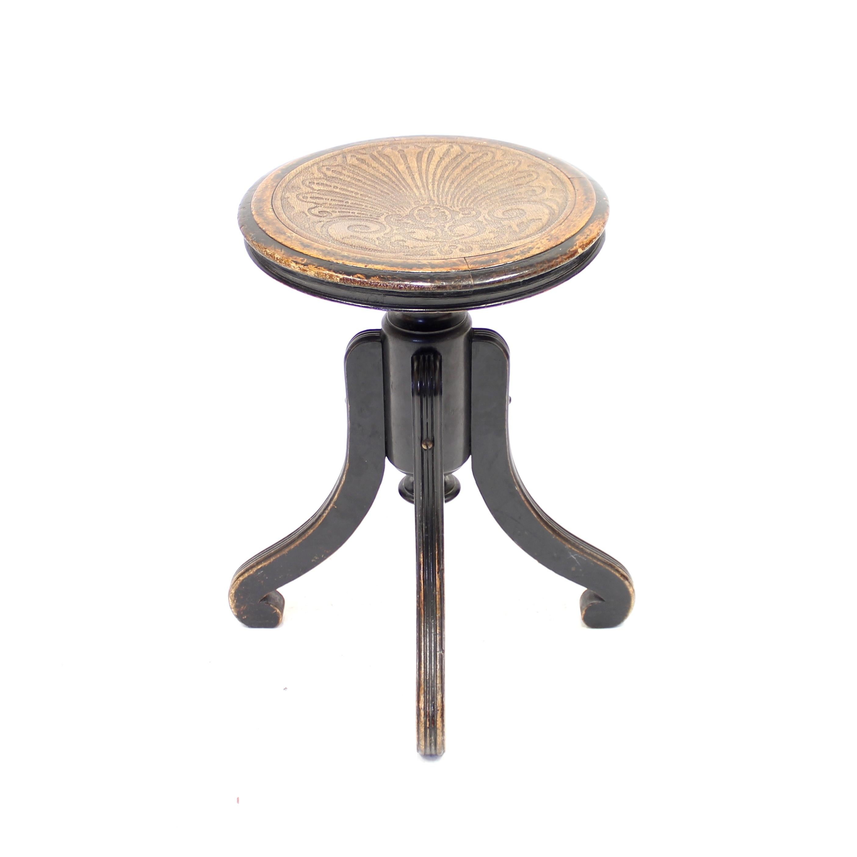 Four legged Art Nouveau stool, in the style of Thonet, with a relief pattern on the round seat. Made around the early 20th century. Base and legs made of eboniozed black lacquered birch. It also contains a little brass ring under the seat for