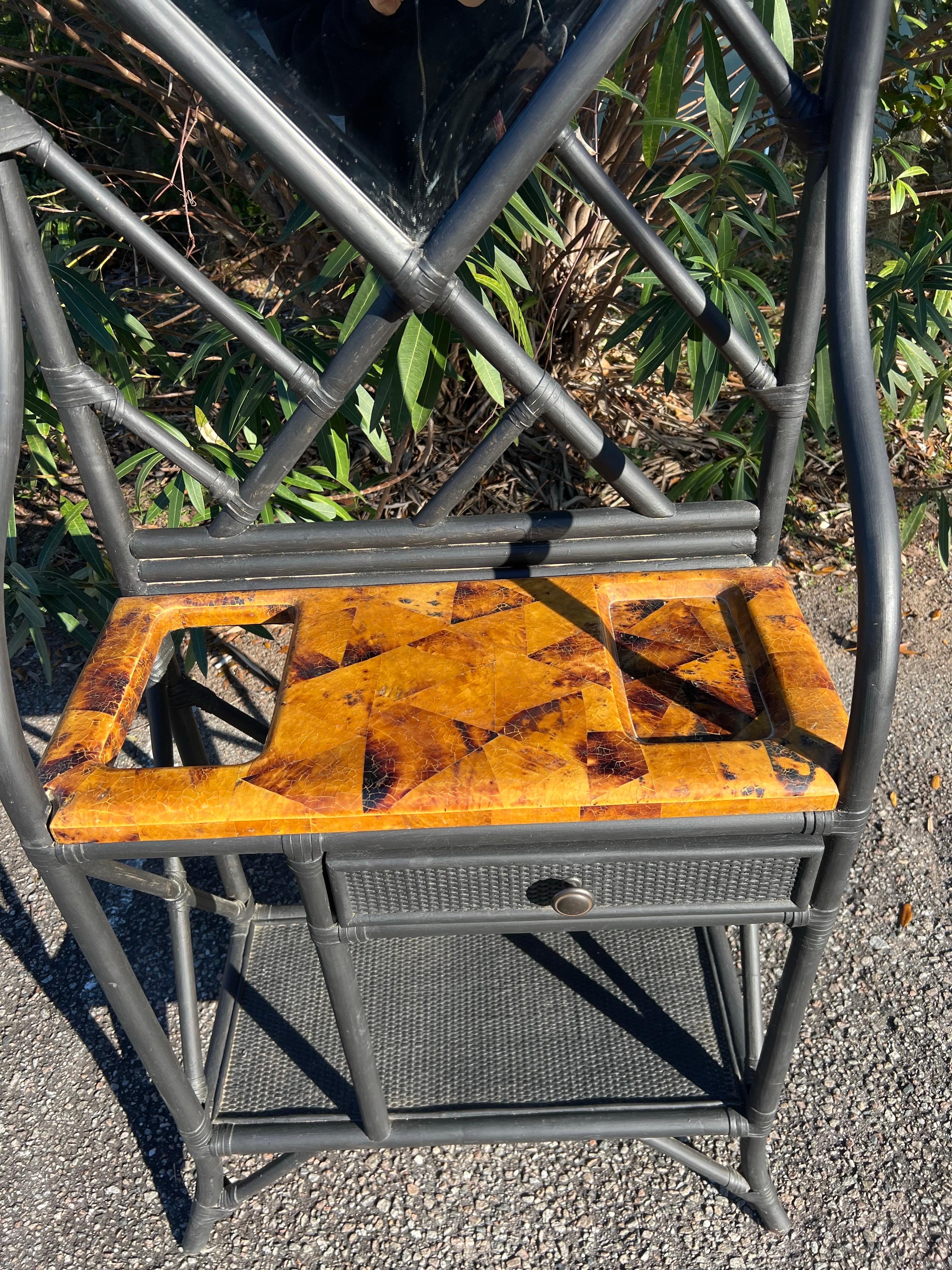 A 20th Century bamboo, woven wicker and faux tortoise shell hall tree.  It has a pretty beveled hexagon mirror, a hole to put your umbrellas, hooks for your hats and coats, a spot for your keys, a drawer and even a lower shelf.   Lots of storage on