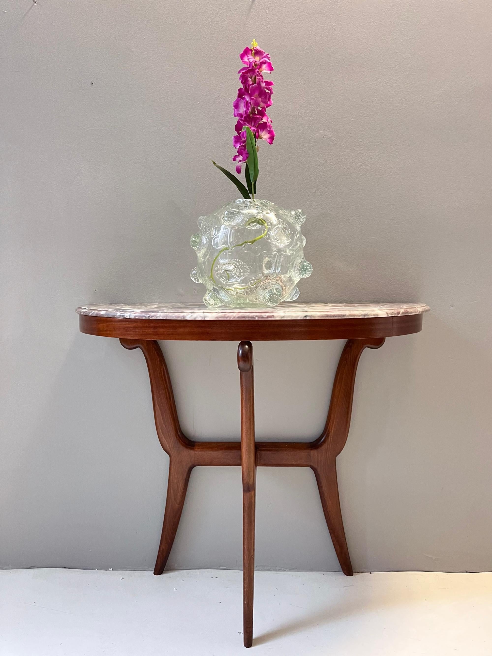 Made in Italy, 1940s - 1950s.
This console table has an ebonized beech frame and a demilune fleur de pecher marble top. 
The wooden frame has a slight flaw, as shown in the pictures, but it's been carefully polished.
This very elegant console may