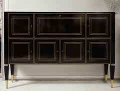 Mueble a medida de estilo neoclásico con acabado ebonizado, con incrustaciones de latón en las patas cónicas