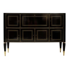Mueble a medida de estilo neoclásico con acabado ebonizado, con incrustaciones de latón en las patas cónicas