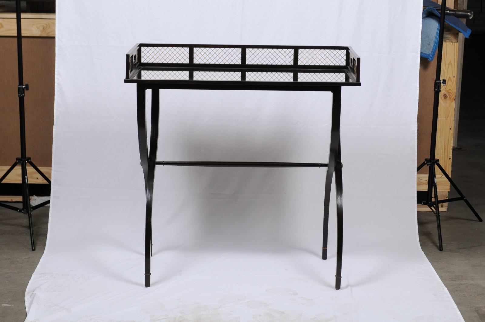 A sleek ebonized Campaign-style Curule form dry bar or mixing table having mirrored tray top and central stretcher. Measures: Height 36