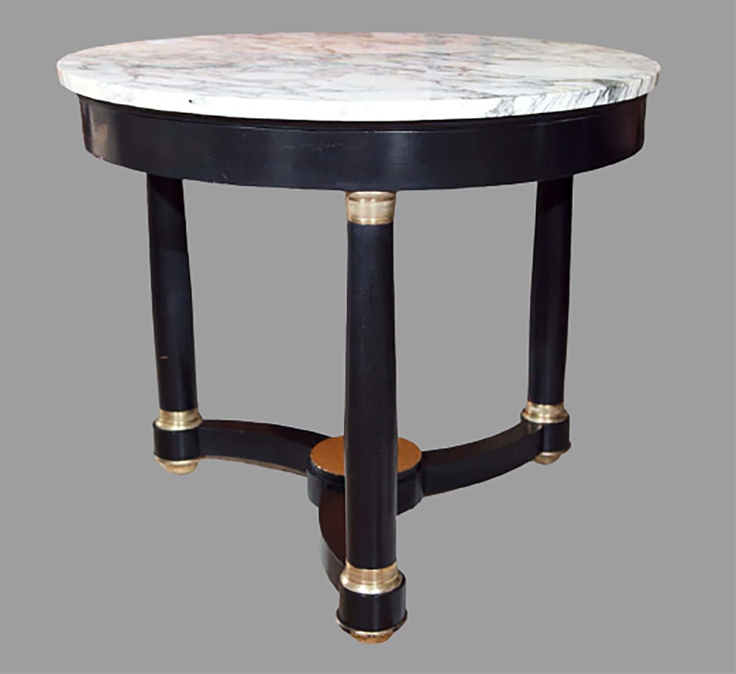 French Napoleon style center table, 20th century, circular marble atop an ebonized base decorated with brass mounts, joint by a triangular stretcher.