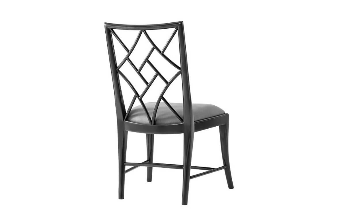 An ebonized mahogany 'cockpen' chair, the trellis back above a drop in seat, the bowed seat rail above splayed legs joined by stretchers. Inspired by a George III original.
       