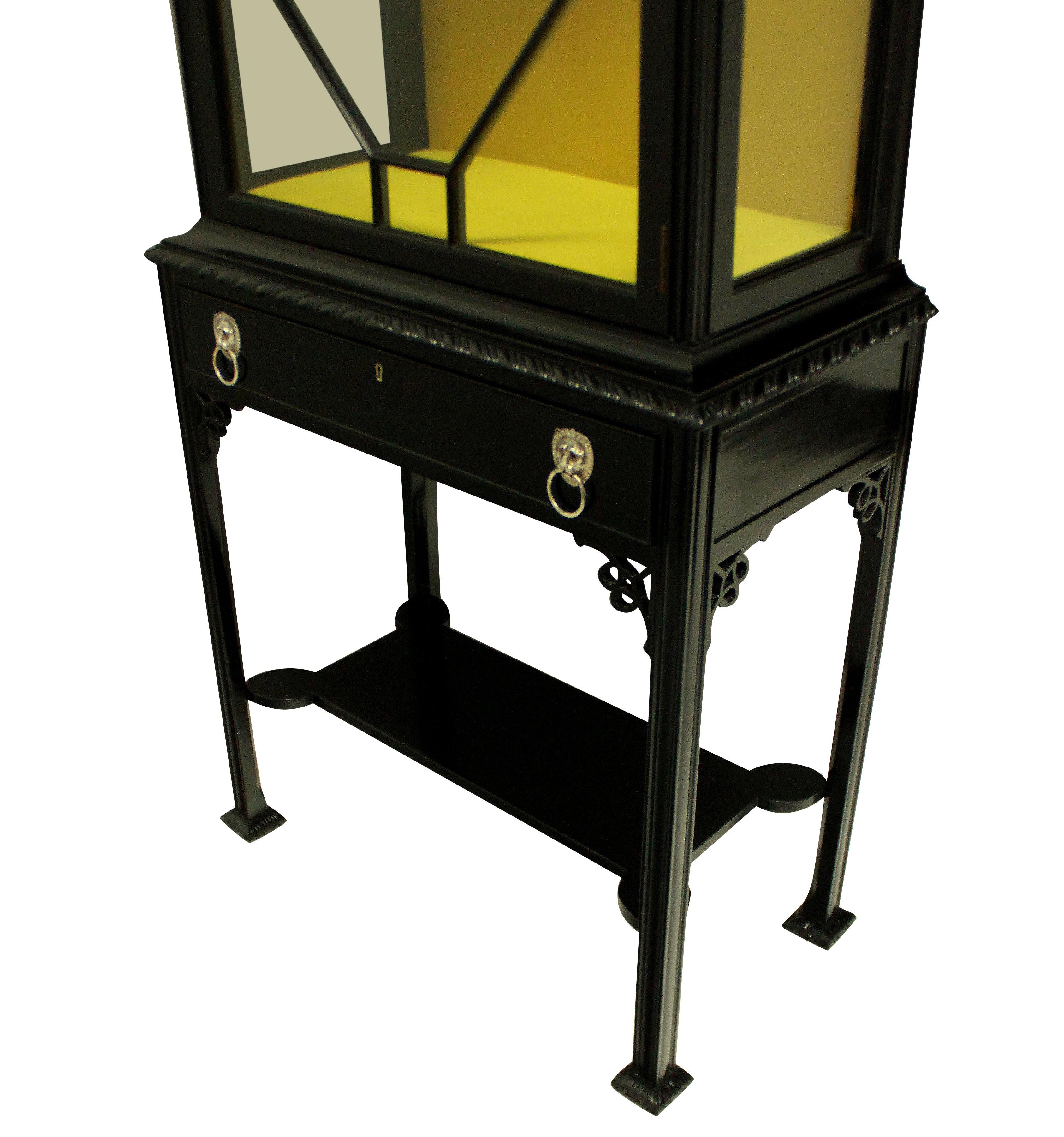 A good quality Chippendale revival display cabinet in black lacquer, designed for Chinese porcelain. With a lower vase stand, single frieze drawer with silver lion mask handles and the upper cabinet with lockable door and shelf. Newly lined in