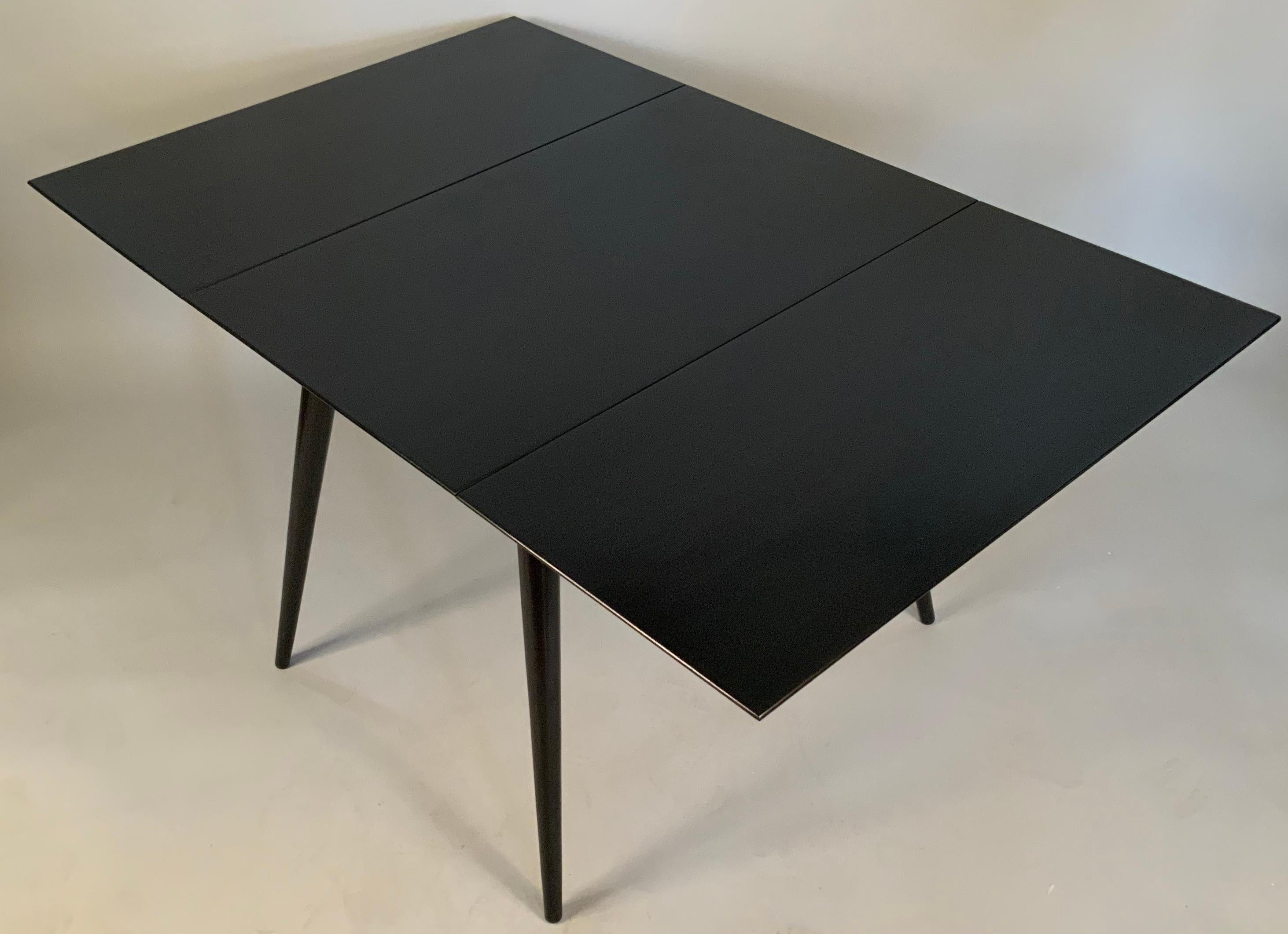 A beautiful 1950's ebonized birch dining table by Paul McCobb. made wtih a pair of drop leaves on the sides, so it can be used in many variations. excellent condition.