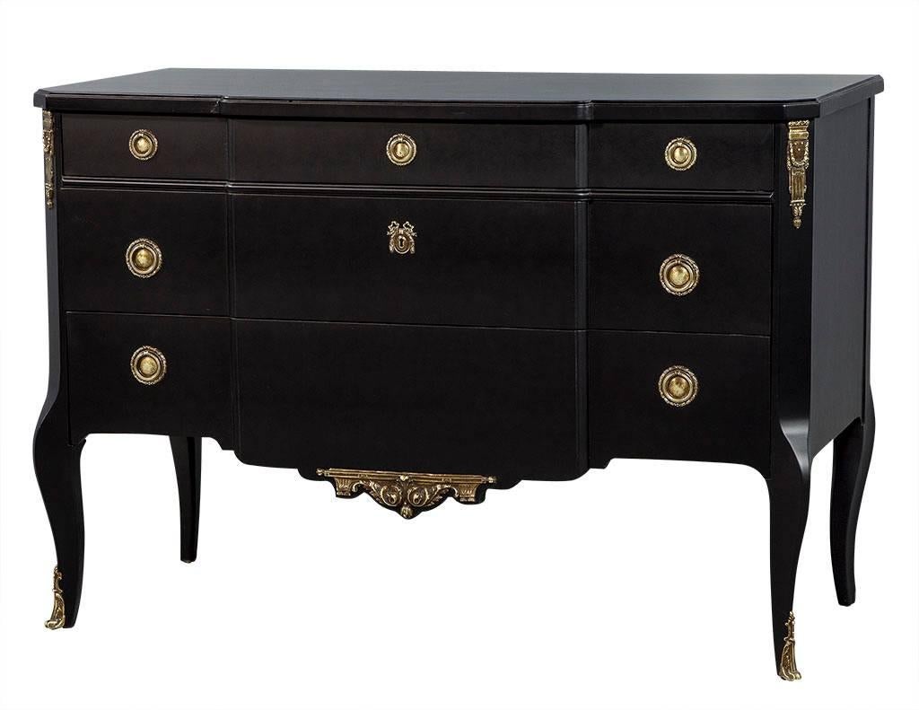 This Directoire style chest is by Ruder of New York City. There are three wider drawers in the middle with two bottom drawers deeper than the top and another section of three narrow drawers on the left and right. Finished in matte black, the piece