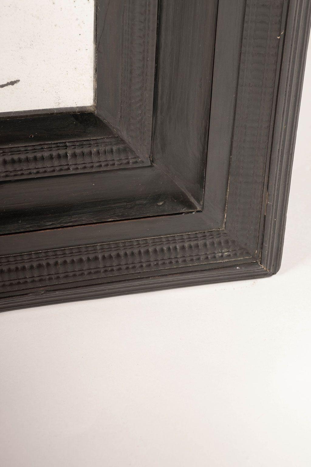 Miroir flamand ébonisé daté du début ou du milieu du XVIIIe siècle. Cadre ébonisé sculpté à la main entourant un ancien miroir en verre (pas le verre d'origine).