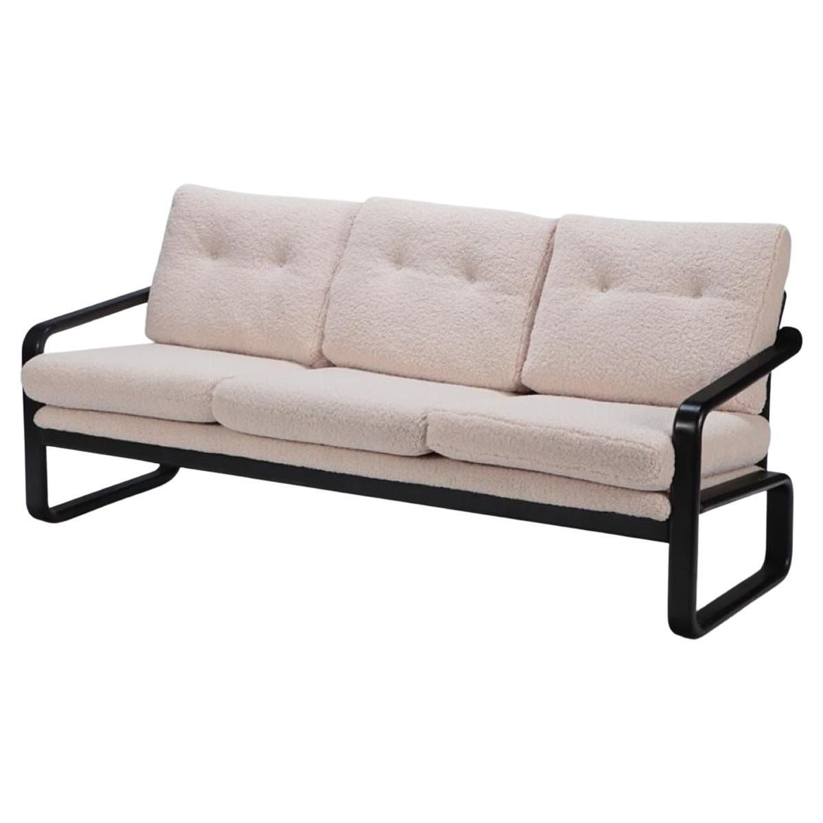 Ebonized French three seat sofa recently upholstered in Boucle fabric For Sale