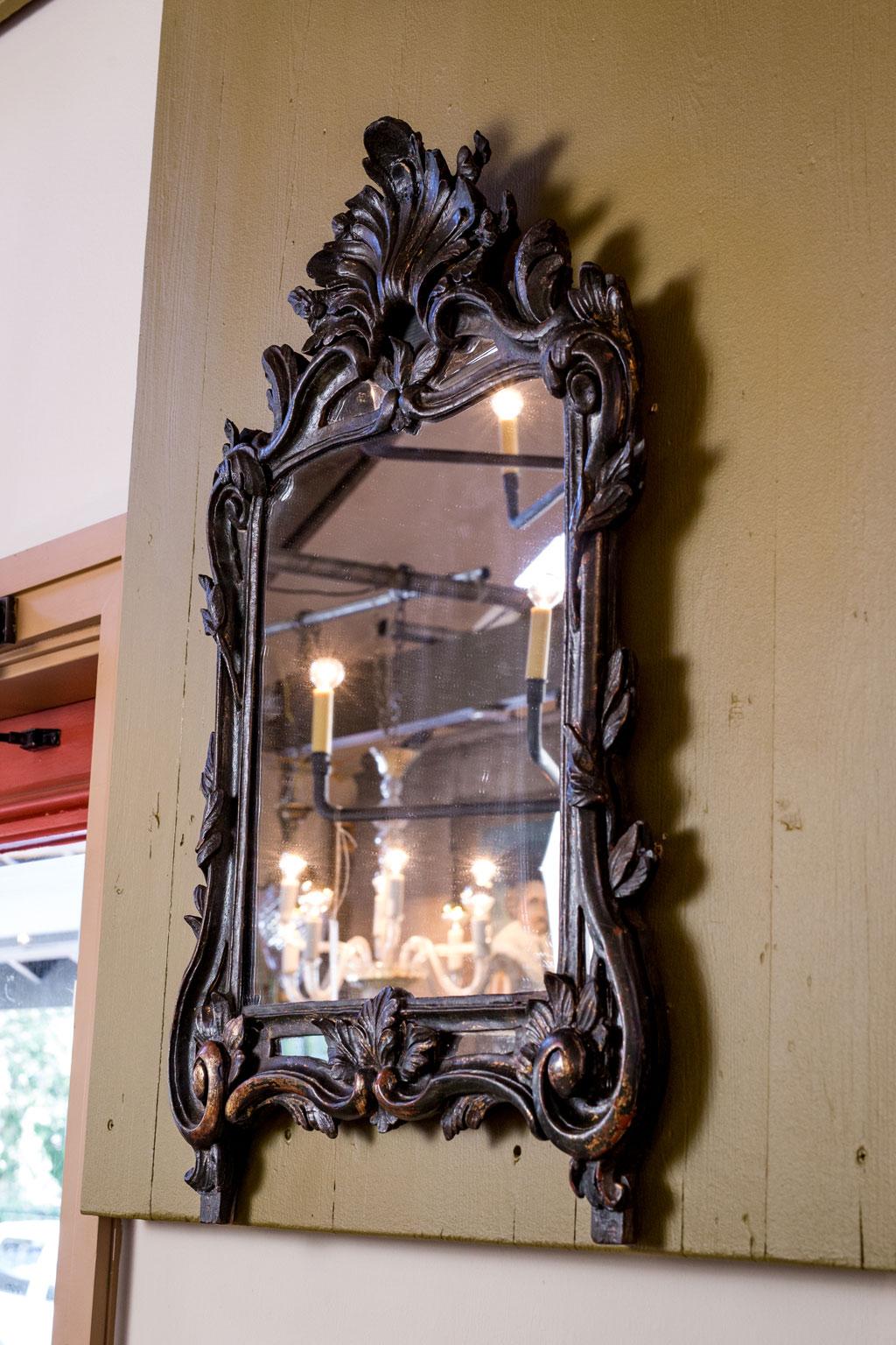 This Special hand carved Italian mirror has wonderful coloring. Circa 1880. Beautifully hand carved detail in Rococo style. Portions of finish is worn revealing gilt underneath.
Most of the glass is original with one piece being replaced.  It is