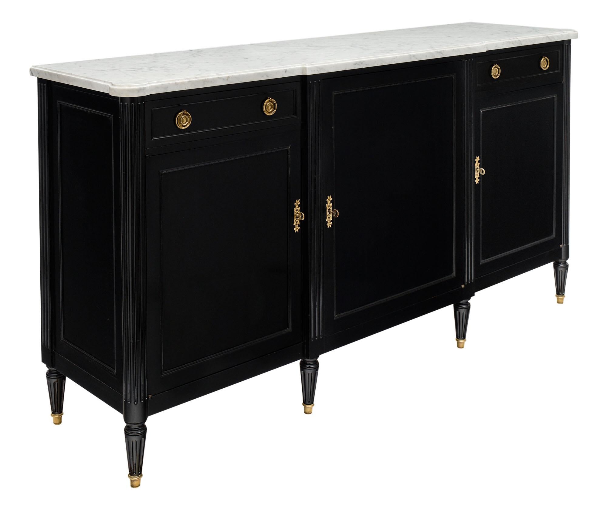 Ebonized Louis XVI Style antique buffet made of mahogany and ebonized with a museum quality French polish finish. We love the finely case gilt bronze hardware; tapered legs; and classically crafted details. It is topped with a beautiful Carrara