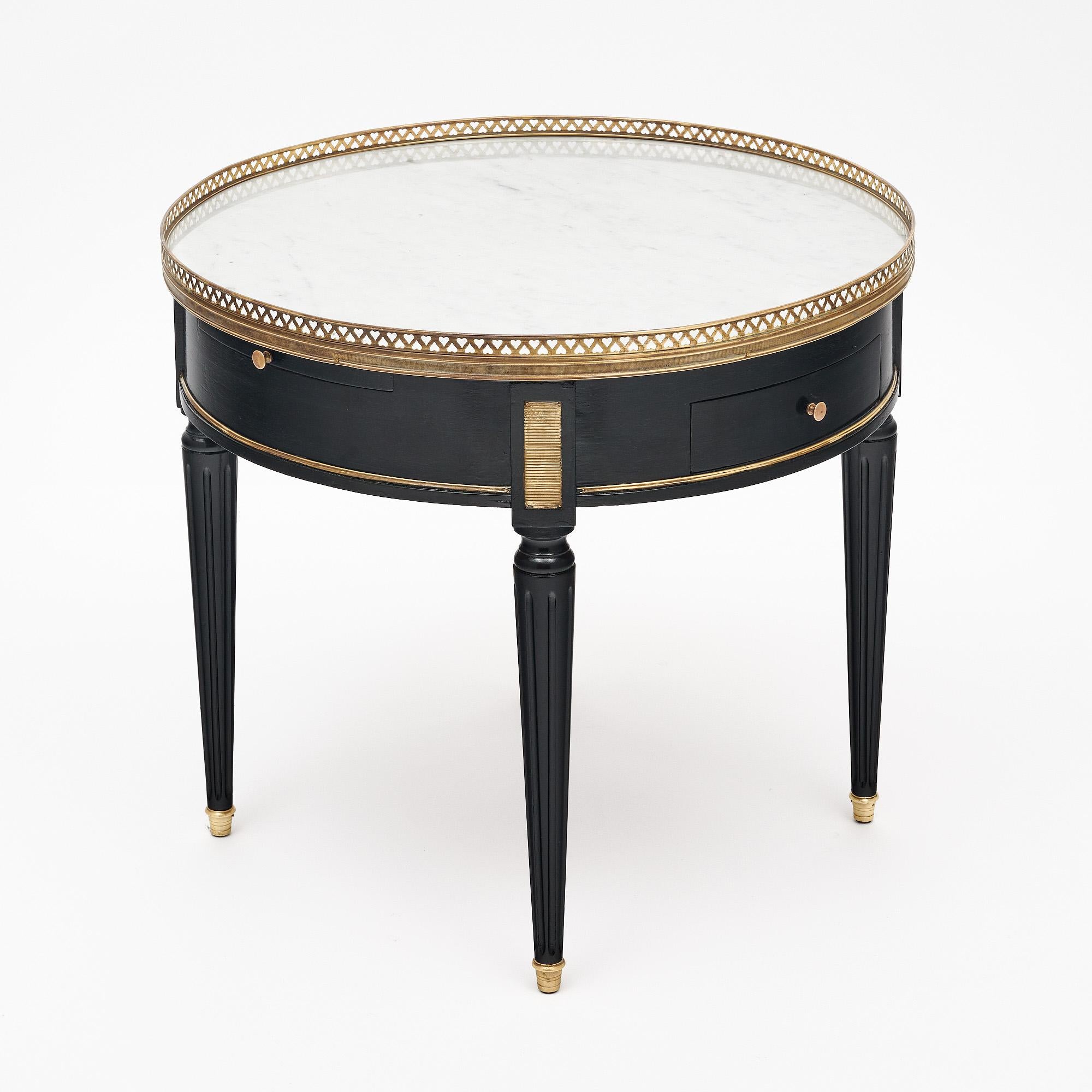Side table from France in the Louis XVI style. This bouillotte side table is made of solid wood construction, primarily mahogany. It has been ebonized and finished with a lustrous French polish of museum quality. The four tapered legs are fluted and