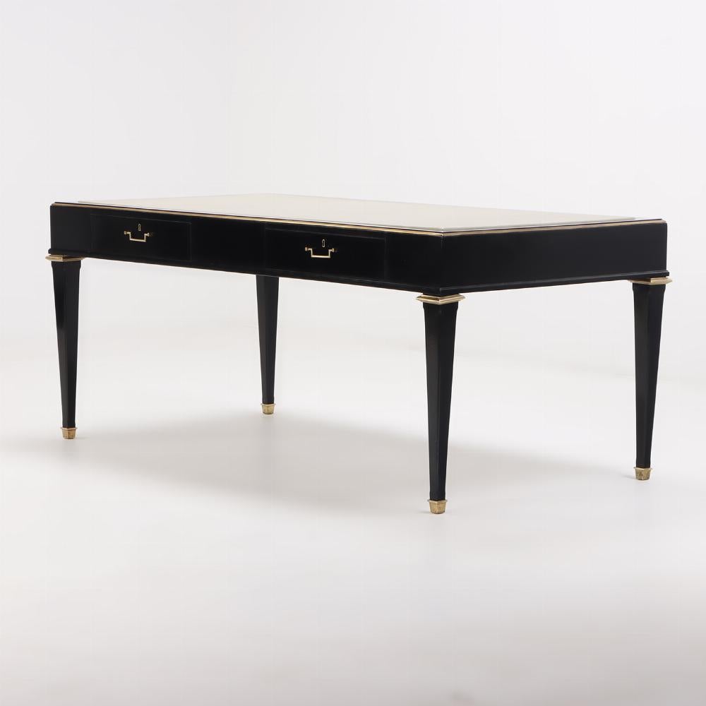 Ebonized mahogany leather top desk in the manner of Andre Arbus C 1950. The case trimmed in bronze having two drawers and a new leather top with gilt embossed border resting on tapered legs with bronze capitals.