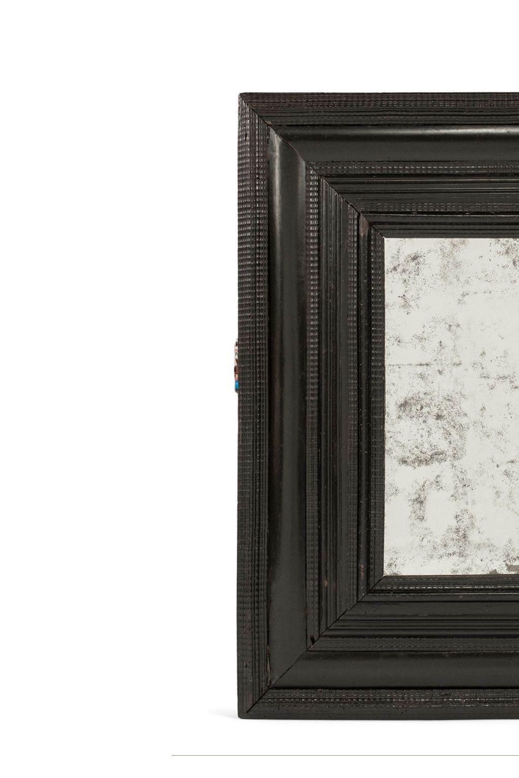 Ebonized mirror dated to early-to-mid-18th century. Hand-carved ebonized frame surrounding old mirror glass (not original glass).