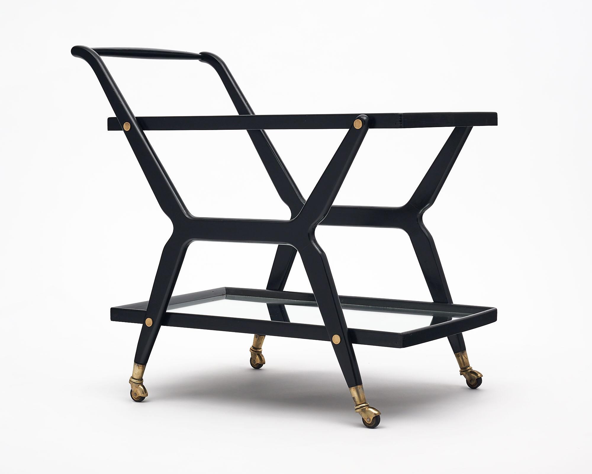 Bar cart from France which has been ebonized and finished with a lustrous French polish. This piece has lovely lines and brass casters. The top shelf is glass while the lower shelf is mirror.