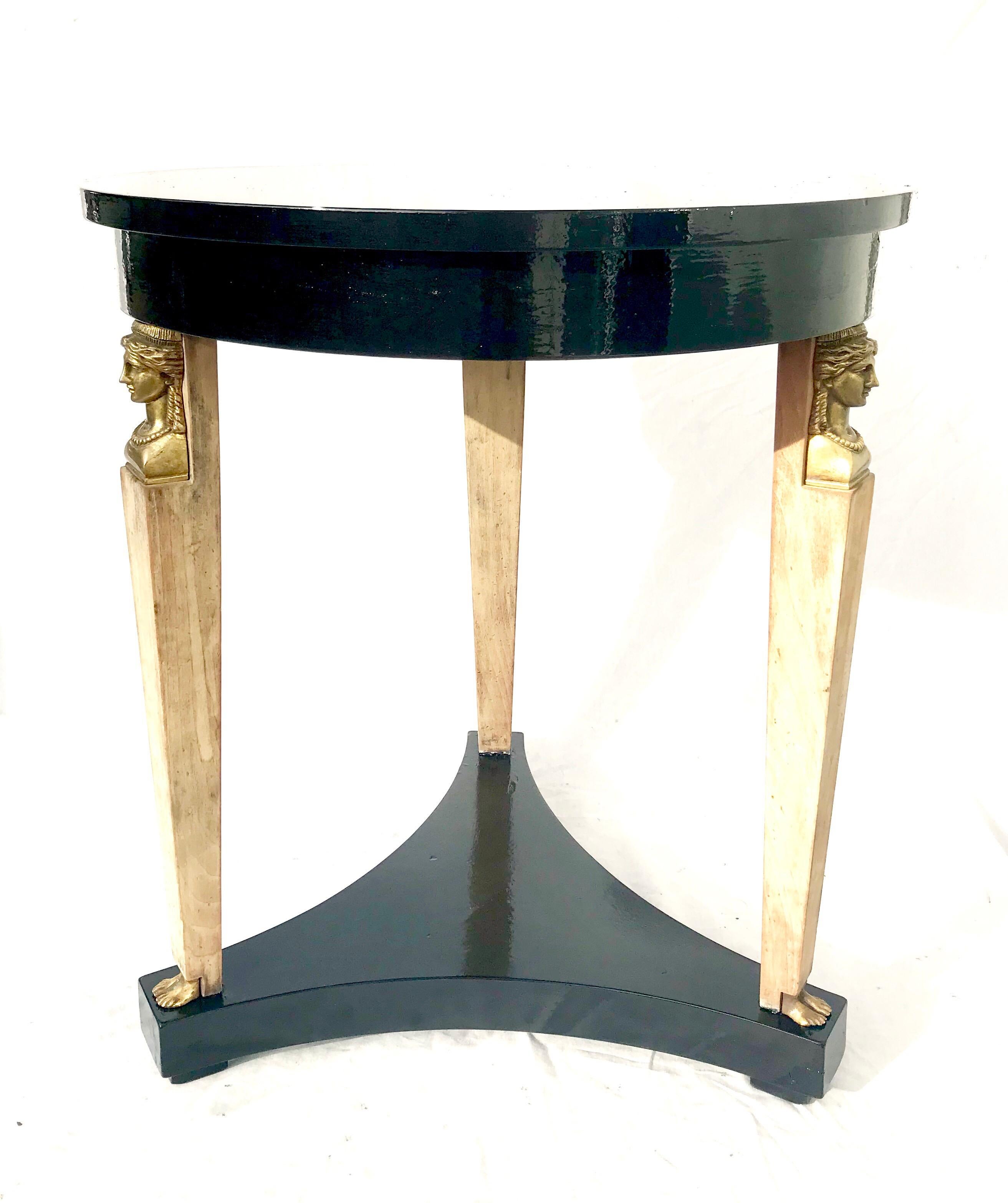 A striking neoclassical revival end table by Baker Furniture, circa 1980. The table shimmers in a recently applied black lacquer by Fine Paints of Europe. The gently tapering legs are beautifully accented by bronze 