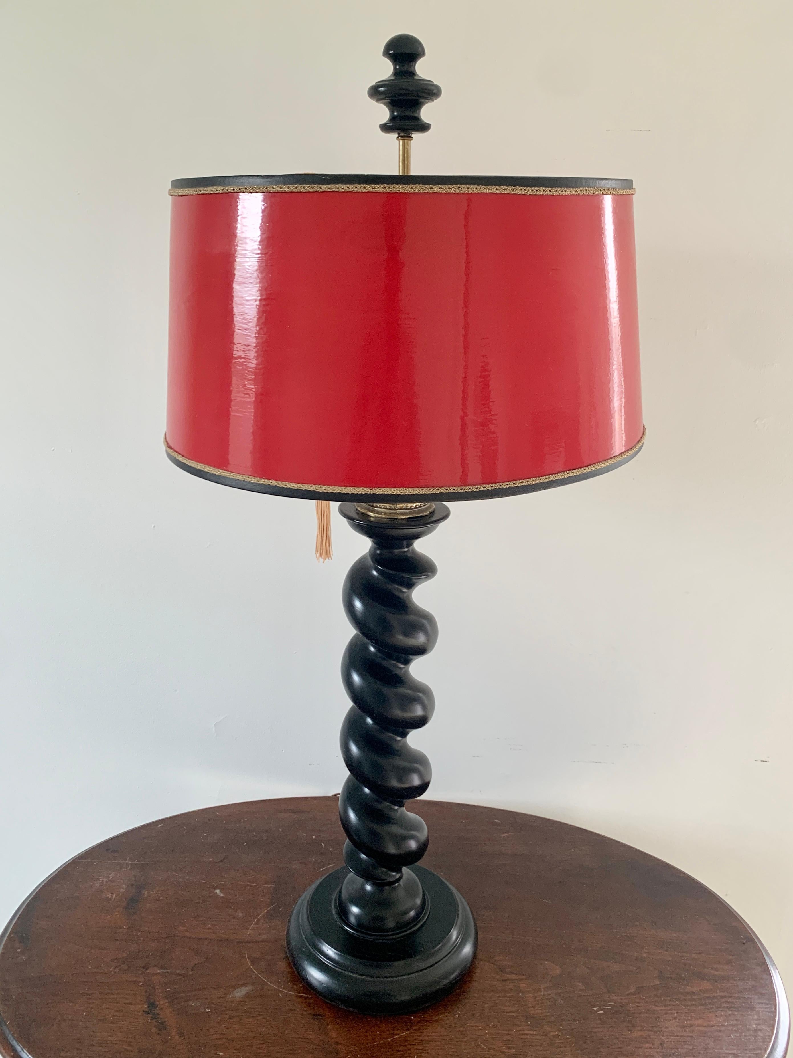 A gorgeous barley twist English style table lamp 

USA, Mid-20th Century

Ebonized oak, with red lacquered shade

Measures: 16