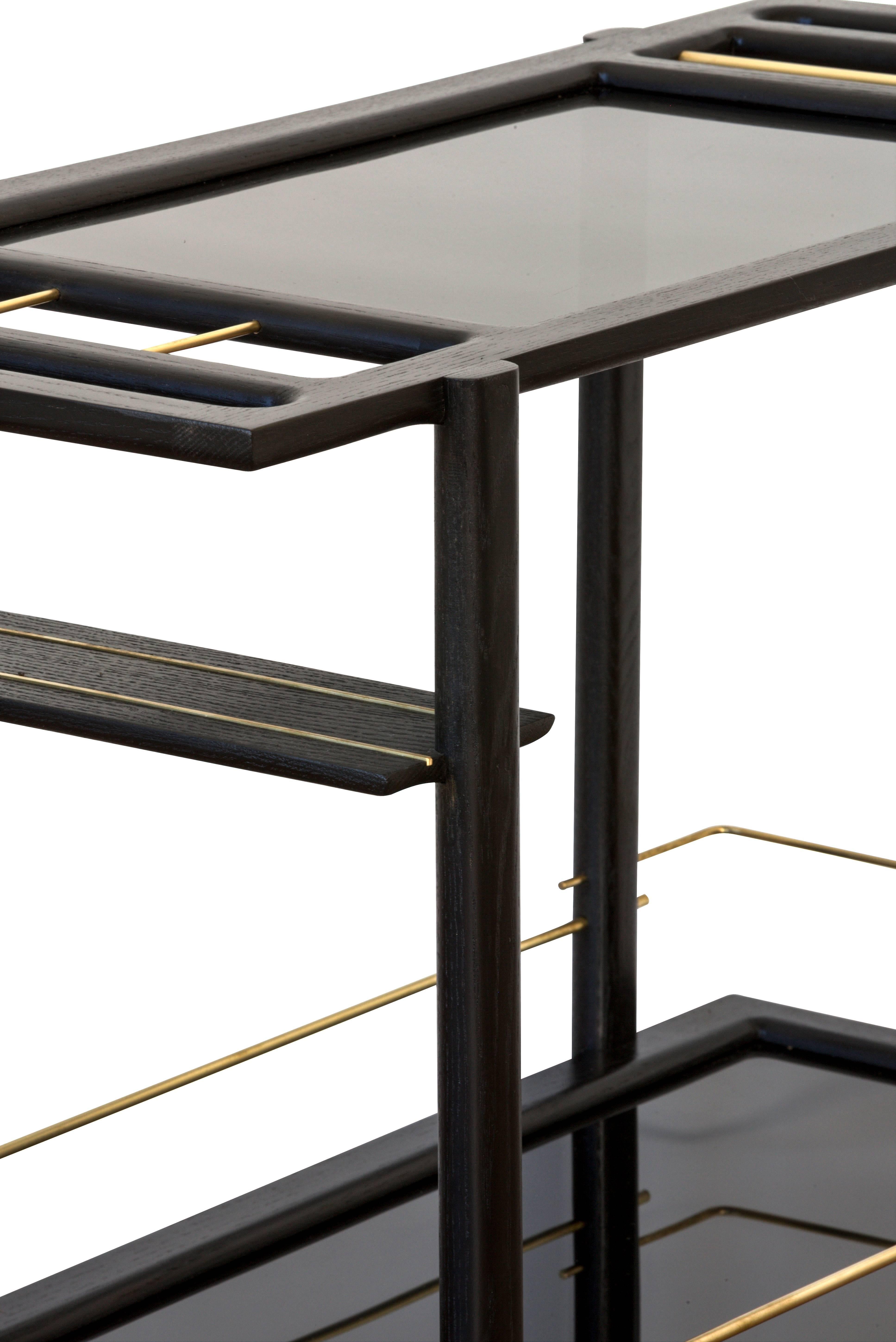 Solid wood constructed barcart with hand-cut joinery, tempered glass panels, and fine metal accents. Handmade in Los Angeles, California. 

Shown in ebonized oak, brass with smoked glass. 

Wood type is available in ebonized oak, white oak,