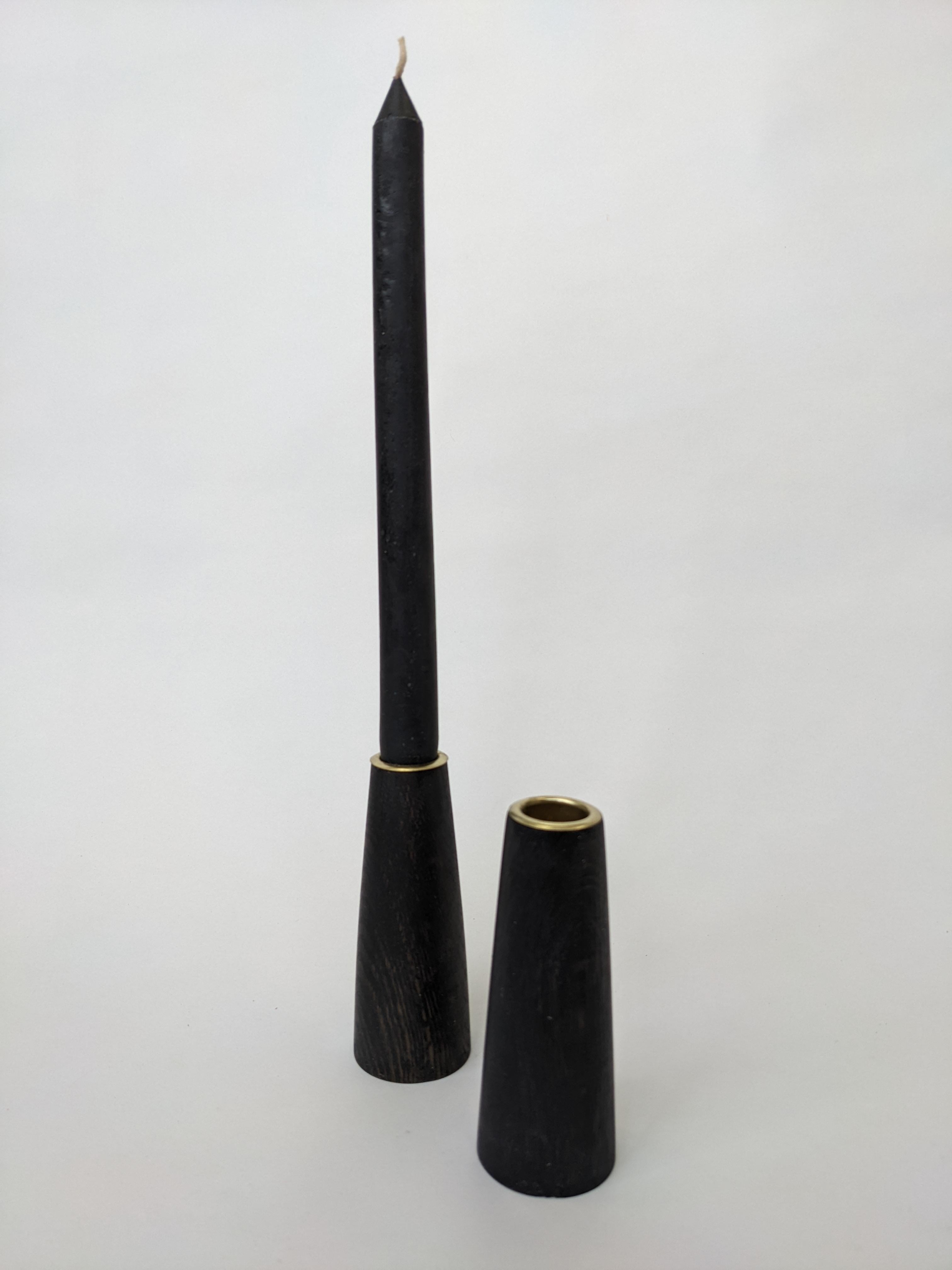 Ebonized Oak candle sticks with brass ferrules. 
Elegant, hand crafted, perfect for the holiday season, or any time.

This item is designed by Fuugs and made from salvaged trees, milled by us, dried and crafted into furniture by hand in
