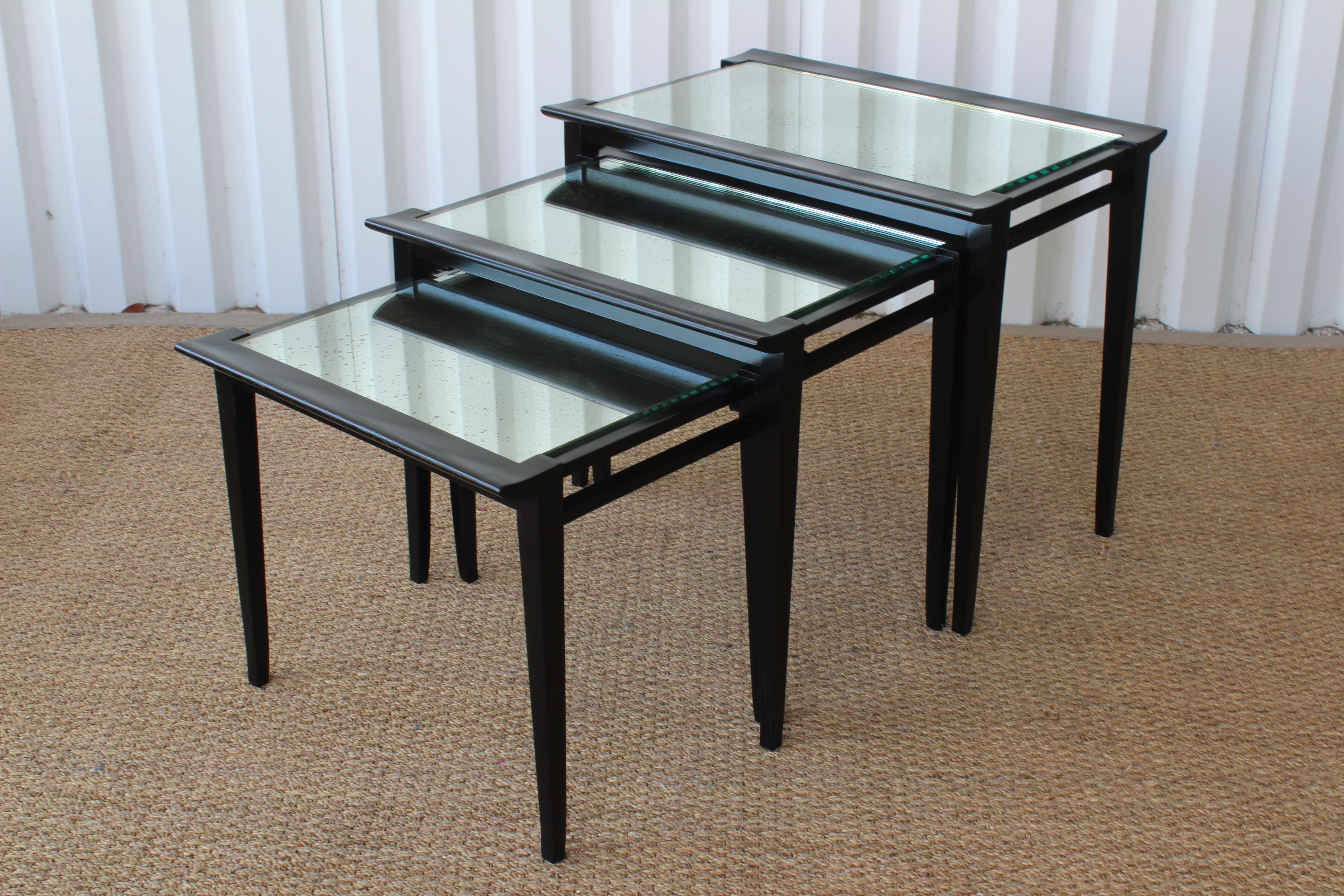 Set of three midcentury 1950s nesting tables in oak. Each table has been refinished in satin black and fitted with custom antique glass tops.
Measures: Large table is 26.5