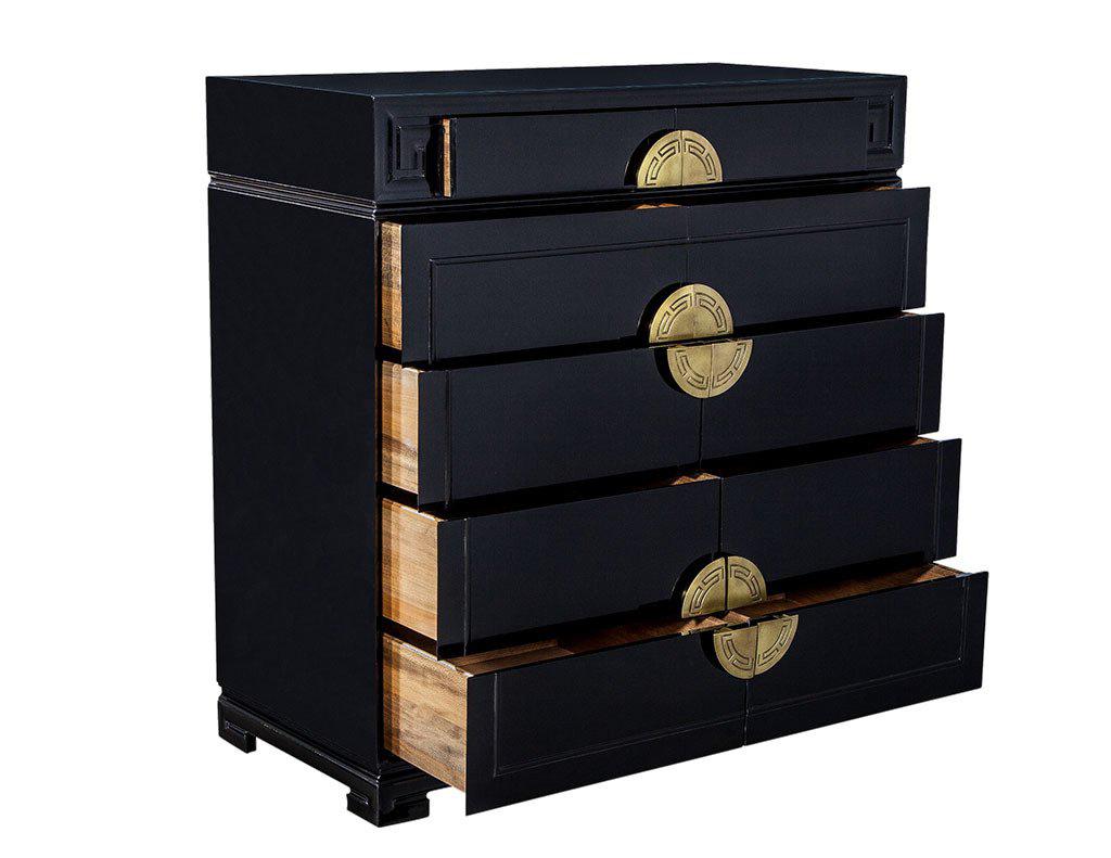A sophisticated storage unit that scores full marks for both functionality and style. A compact wooden body is divided into two top drawers and eight lower drawer compartments, featuring round brass Greek key motif embossed hardware, with the