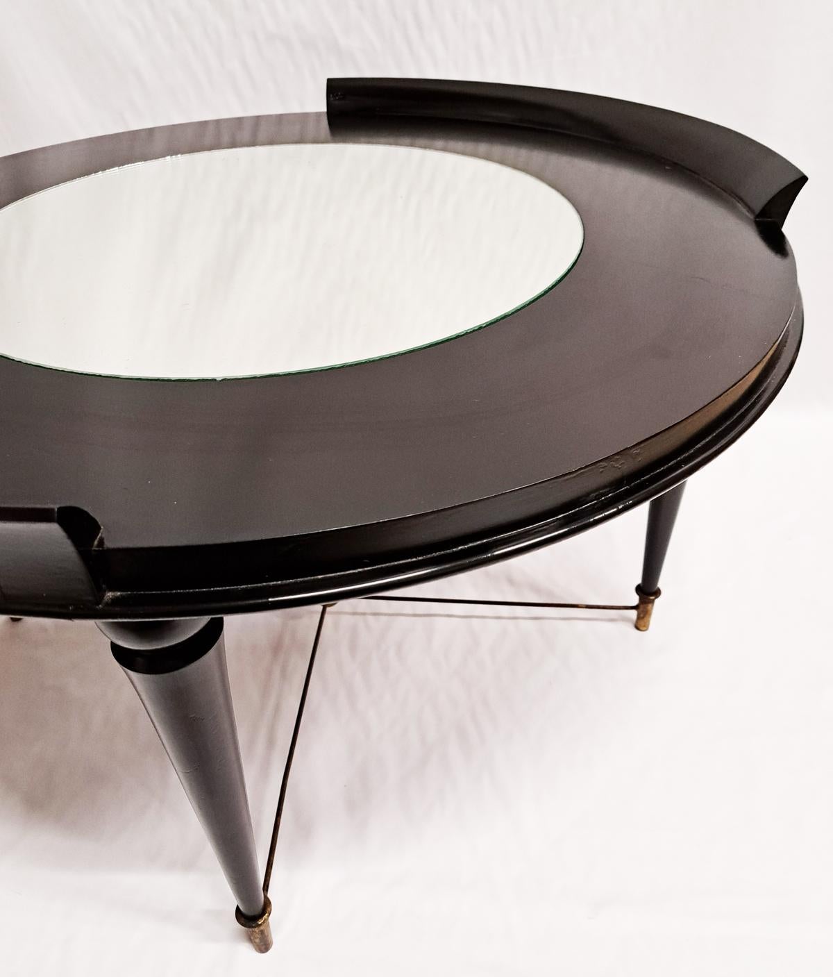 Italian 1950s round midcentury coffee/centre table or side table, Art Deco in style, Very elegant Ebonized table, with a mirror top seating in the middle. The mirror is original to the table and shows some mercury age to the glass! 
The four legs