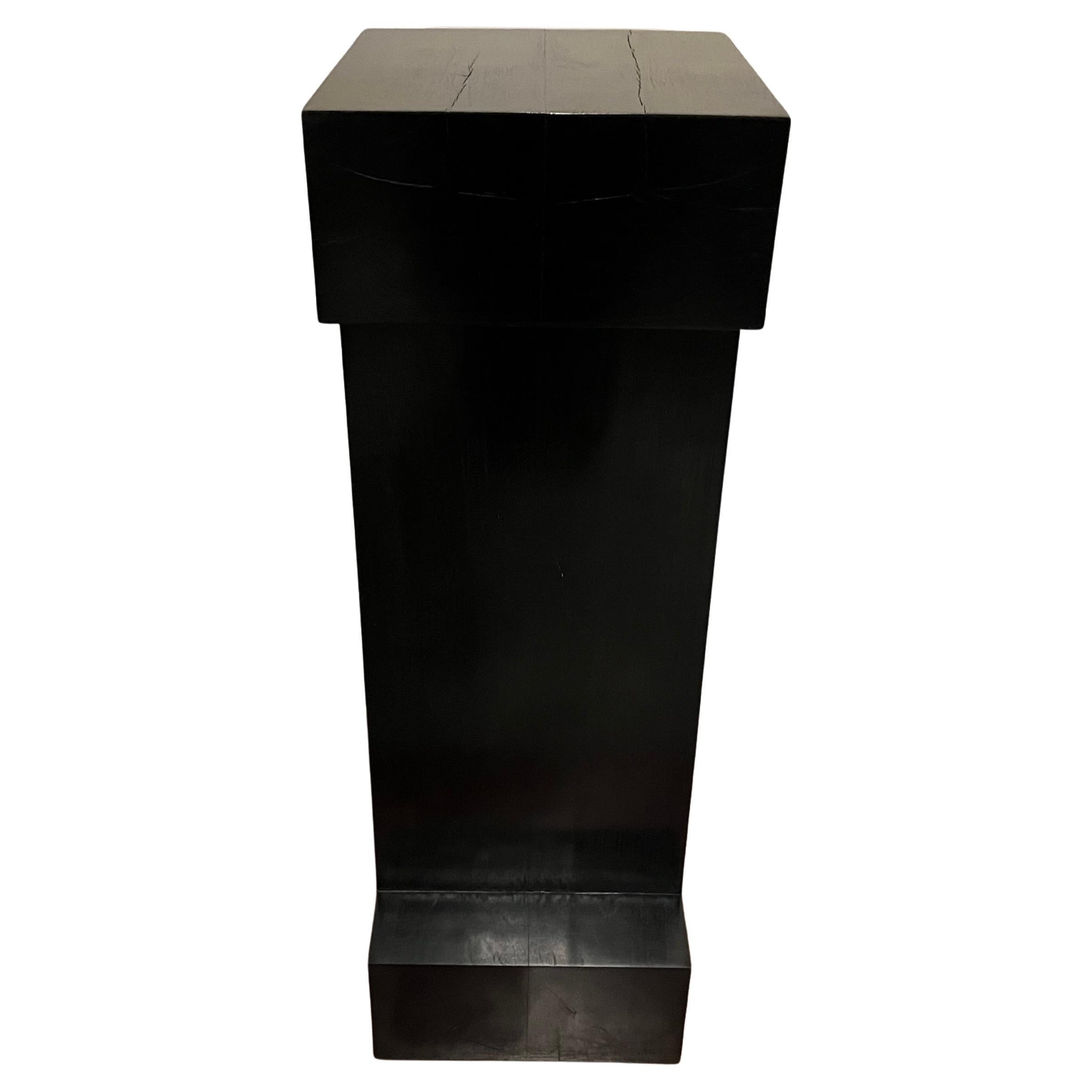 Mesa de pedestal de teca maciza ebonizada by Chista.  Puede utilizarse para exponer obras de arte, artefactos, libros o iluminación.  Chista, fundada en 1990, explora las raíces del primitivismo y el modernismo, lo encontrado y lo escultórico en lo