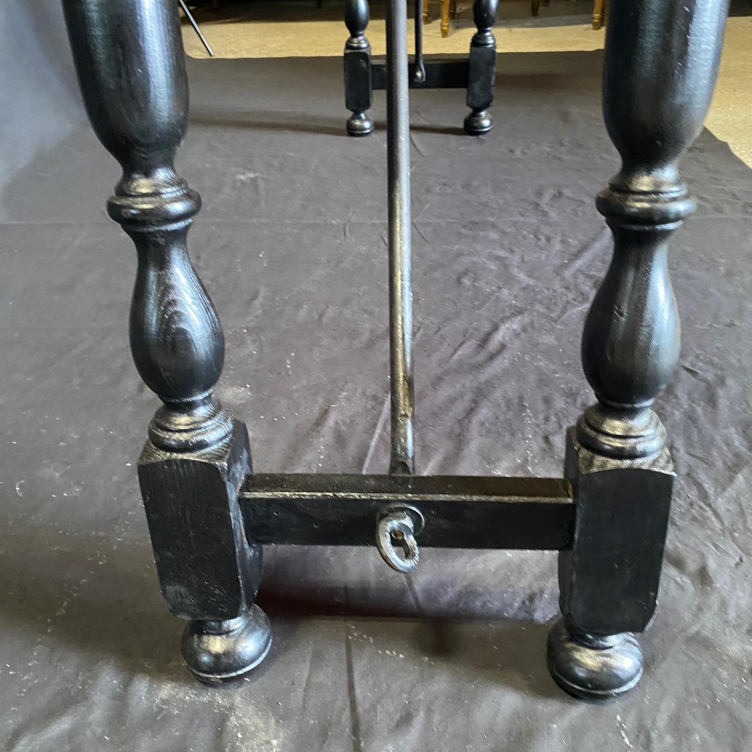 Handsome Spanish black console table boasting hand made wrought-iron stretcher and long rectangular top sitting above exquisite base made of splayed carved and turned legs connected to one another with side stretcher and each side is linked to the