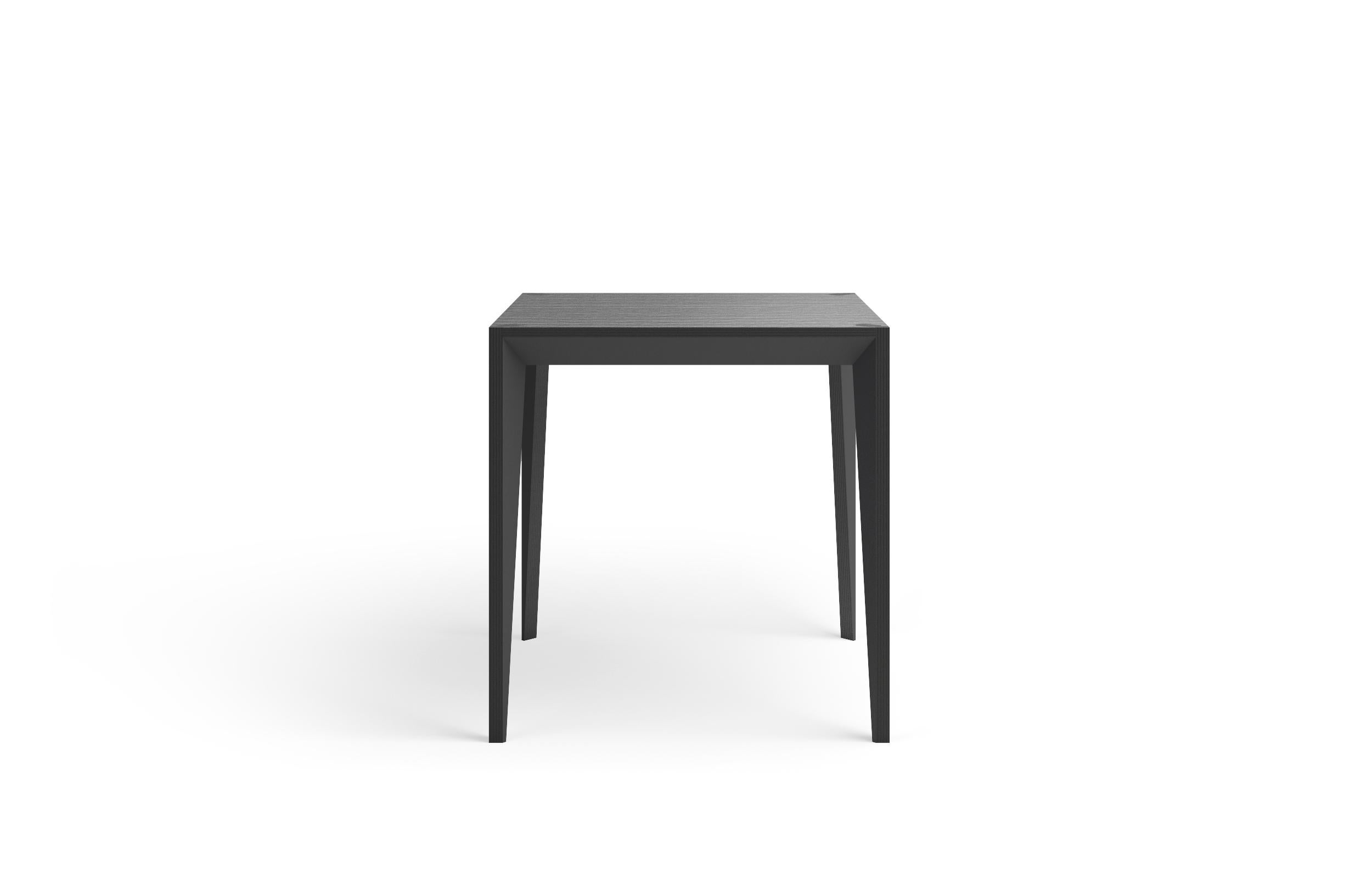 Der quadratische Tisch MiMi verbindet klare Linien mit warmen Materialien und schafft mit seiner facettierten Geometrie ein schlankes, elegantes Profil, das von schrägen Flächen unterbrochen wird, die das Licht einfangen. Die MiMi-Linie war ein