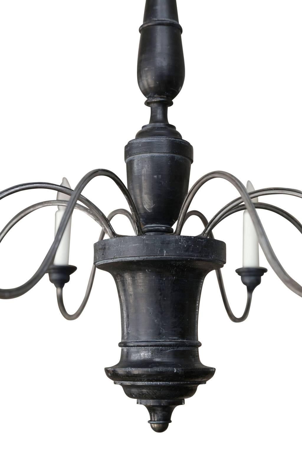 Ebonized wood and iron chandelier from Genoa, Italy. Chandelier consists of a turned wooden body (circa 1800-1820) in original ebonized finish, eight later undulating iron arms and wooden bobeche cups. Newly-wired for use within the USA using all UL