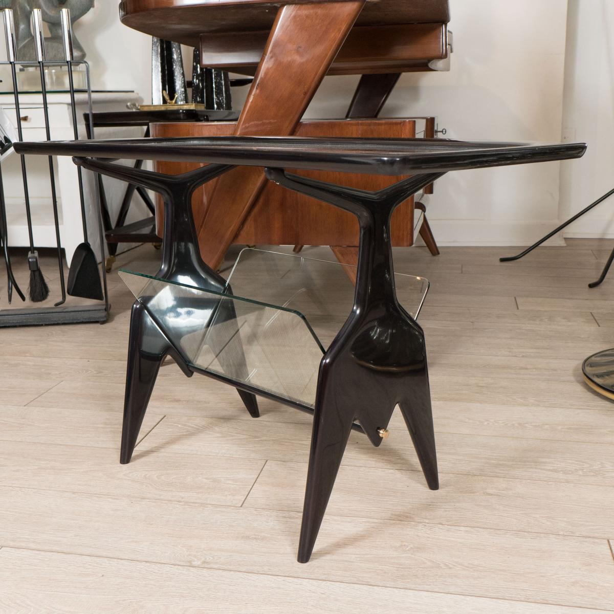 Ebonized wood table with glass top and magazine rack base.